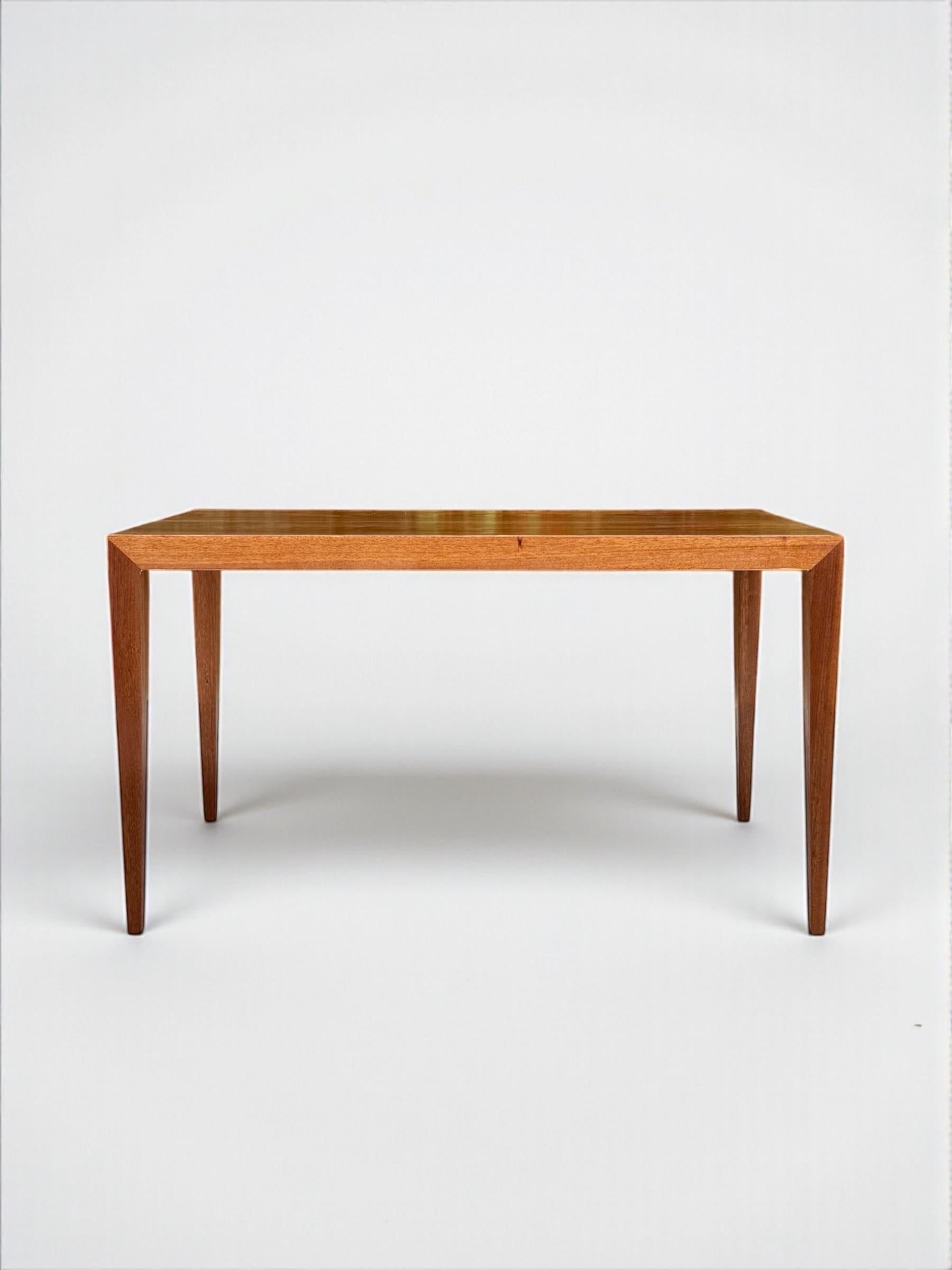 Esta mesa auxiliar de palisandro Severin Hansen es, sin lugar a dudas, la obra de un maestro del diseño. Sus icónicas patas esbeltas y afiladas, con uniones en inglete, hablan de sencillez y sofisticación, sin duda una pieza donde menos es más.