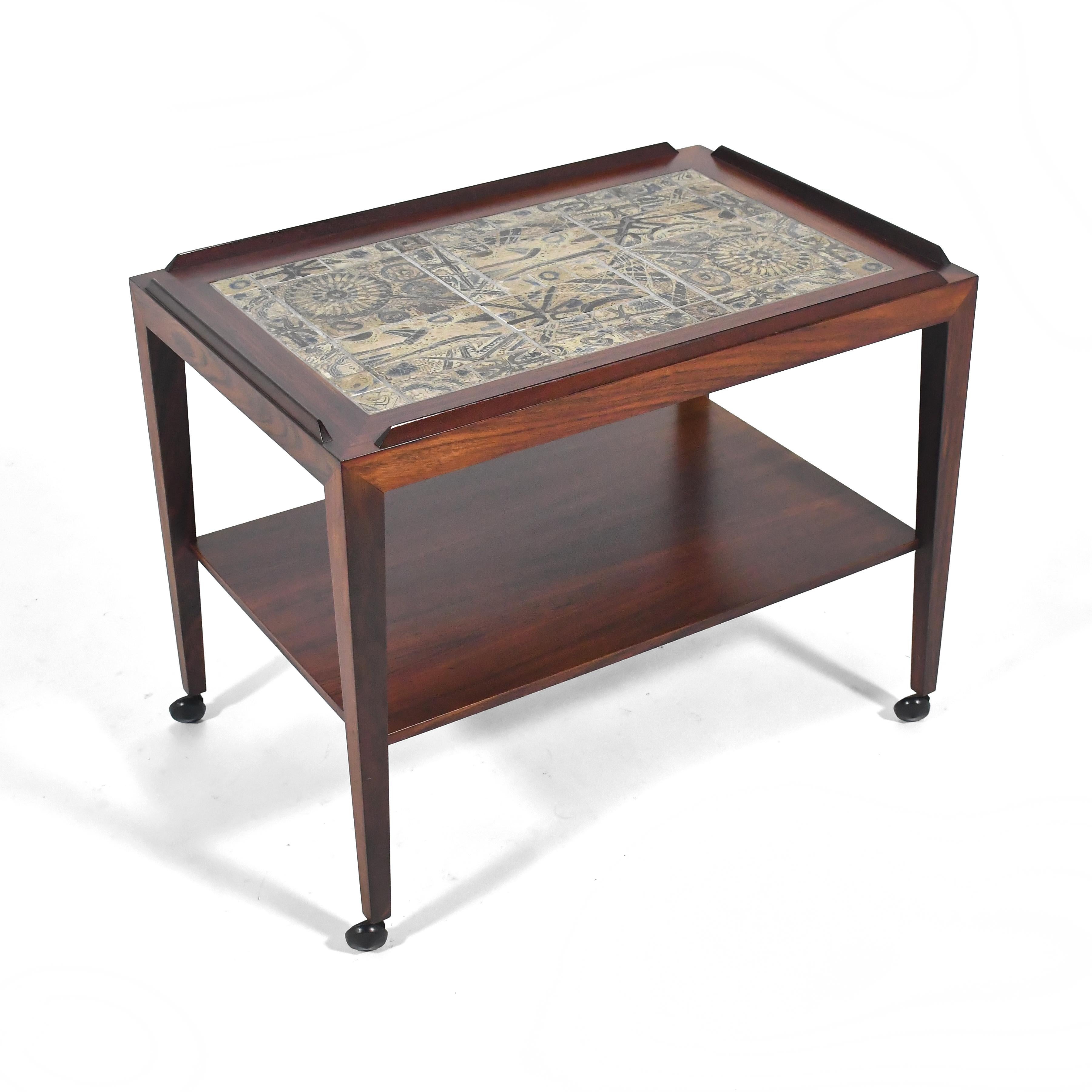 This exquisite Severin Hansen table executed by Haslev Mobelfabrik in rich rosewood has a beautiful top inlaid with Niels Thorsson tile by Royal Copenhagen.

Expertly crafted with many subtle details, the table also has casters, offering it mobility