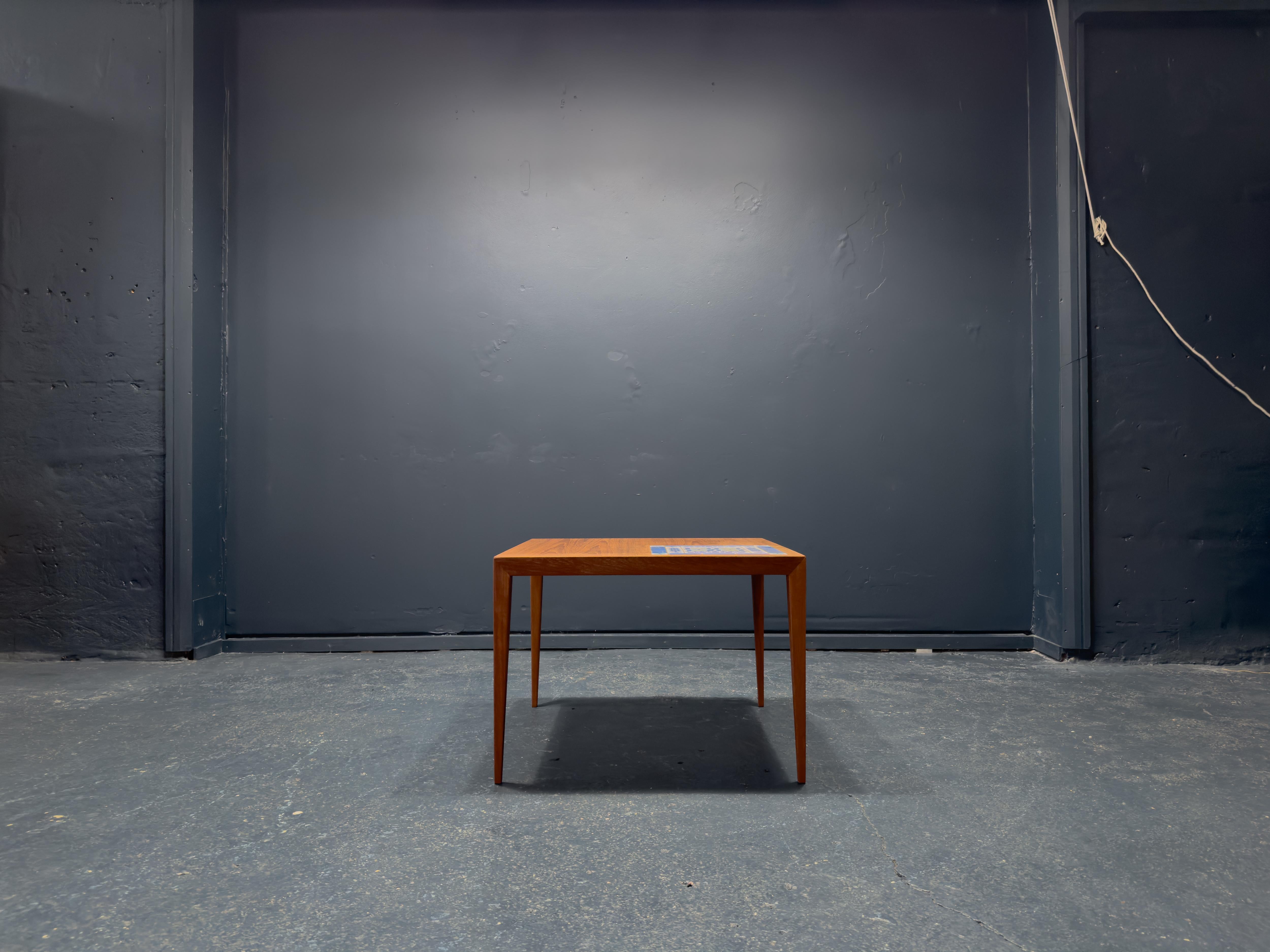 This elegant square teak coffee table was created by Danish designer Severin Hansen in 1960s. The piece has a very compact square shape with 9 strong lines reflected in the unique square tiles inlaid to one corner. The statement addition of the