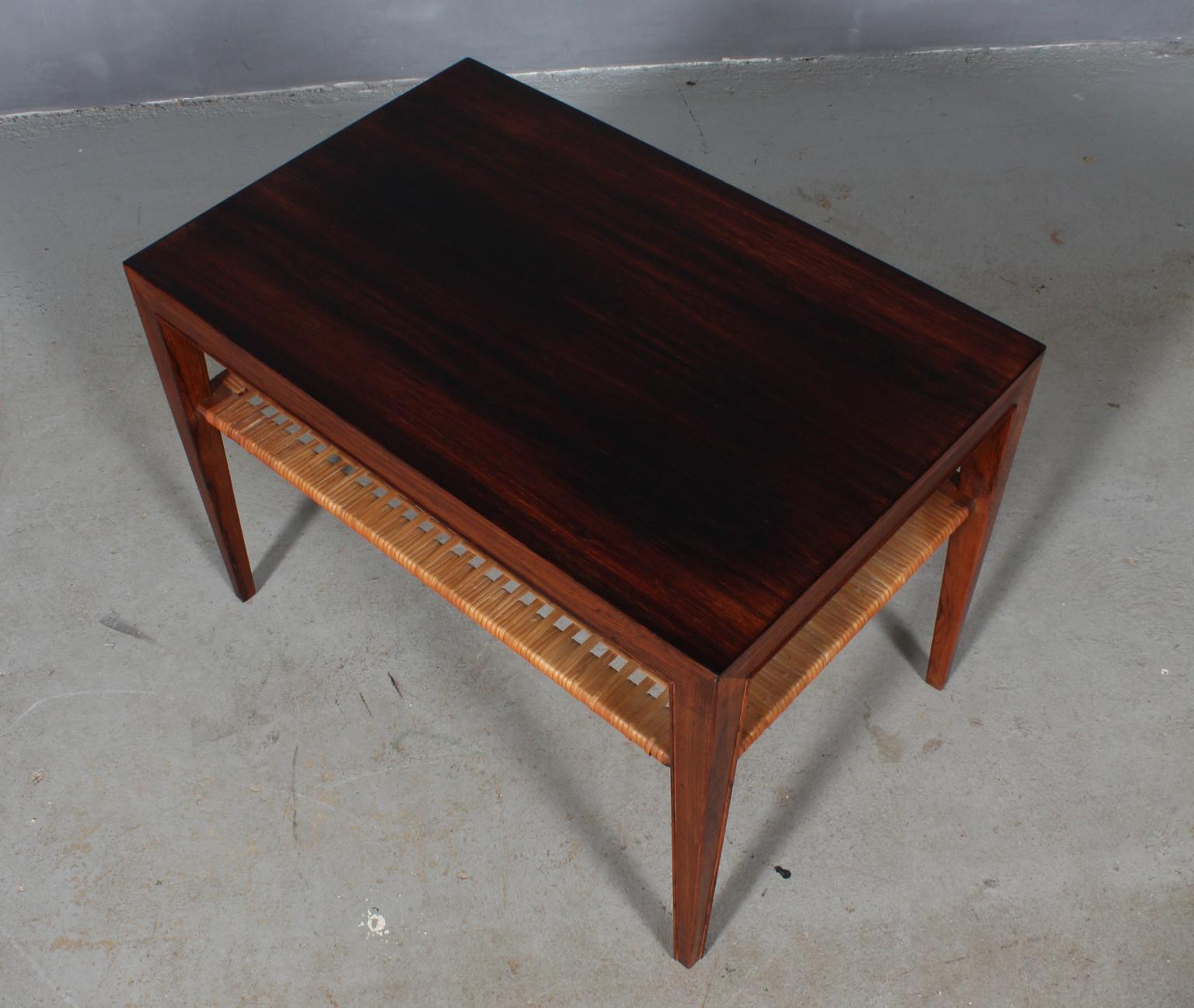 Severin Hansen sofa table / side table in veenered rosewood.

Shelf of cane.

Made by Haslev Møbler, 1960s.