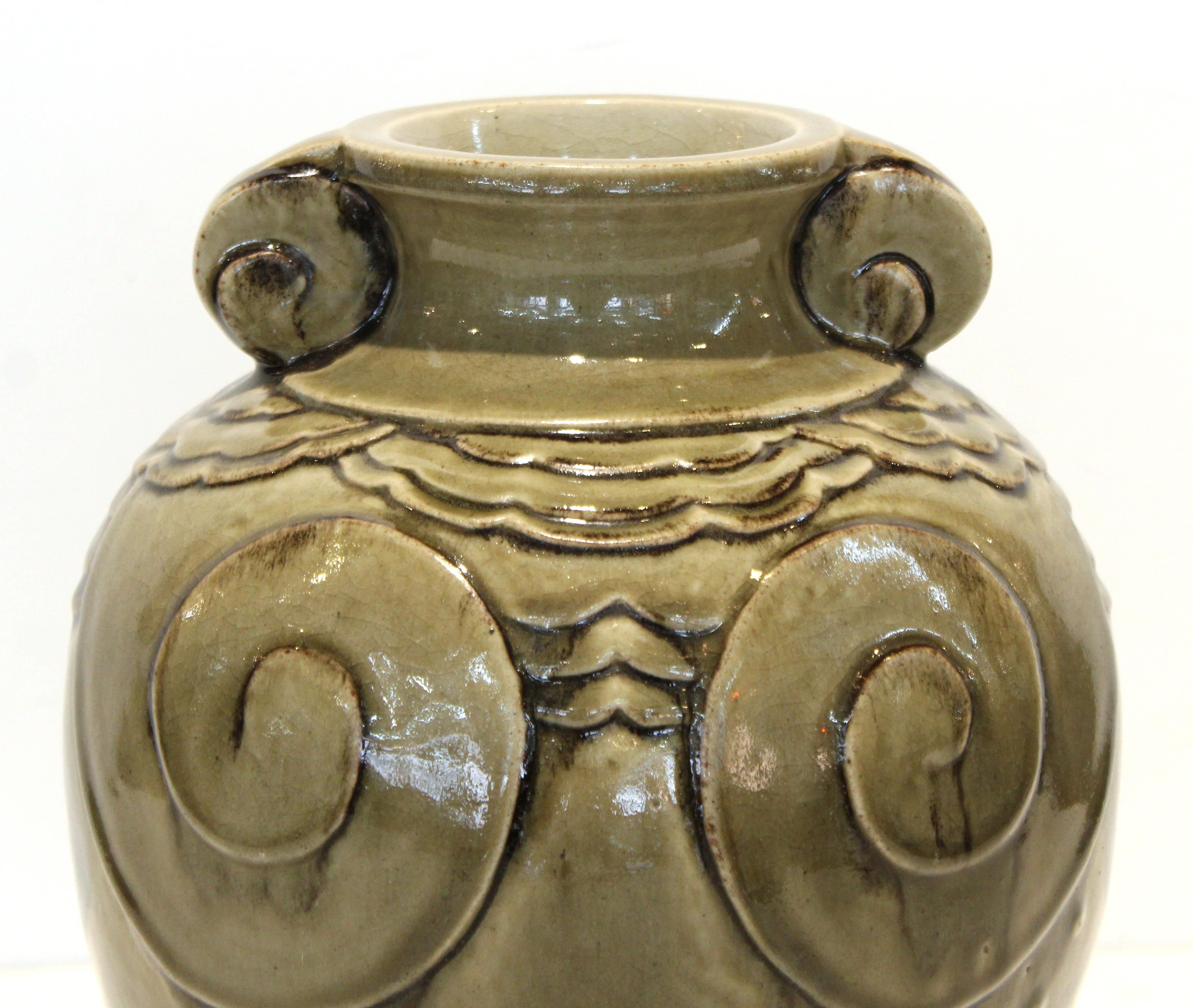 Französische Vase aus hochgebranntem Steingut in Seladongrün aus dem Art Déco-Stil, zugeschrieben in Sevres. Das Stück hat ein dekoratives skulpturales Relief und wurde Mitte der 1920er Jahre in Frankreich hergestellt. Markierung 