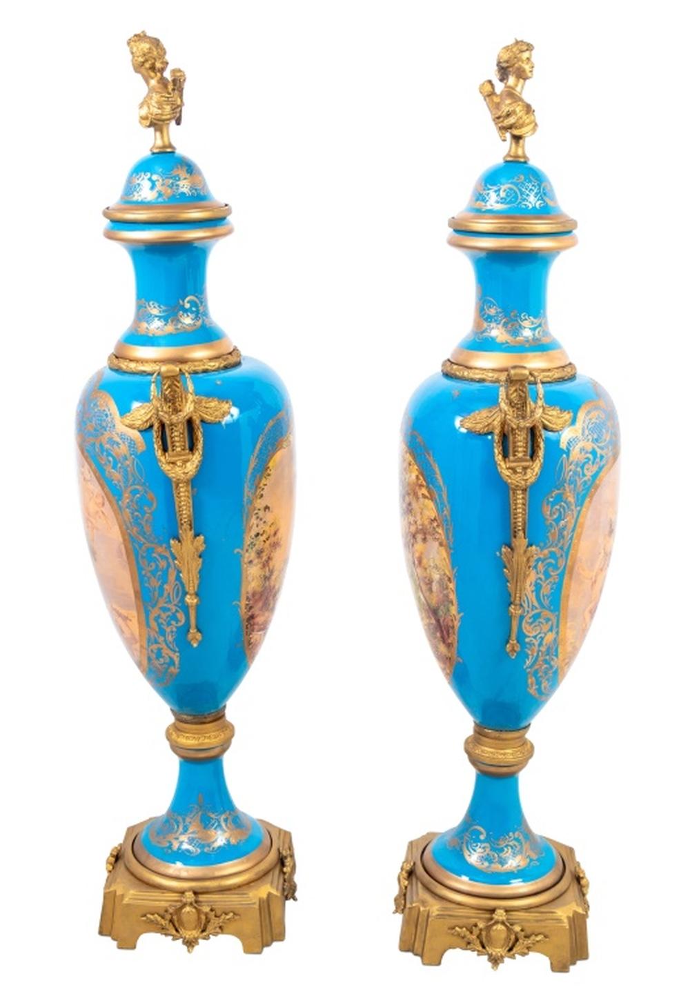 Pair of Sevres Bleu Celeste Ground Gilt Metal Mounted Porcelain Ovoid Vases, early 20th century, each with a domed cover, surmounted by a portrait bust, mounted with ring handles, the bodies with oval panels of scenes after Boucher and Gilbert
