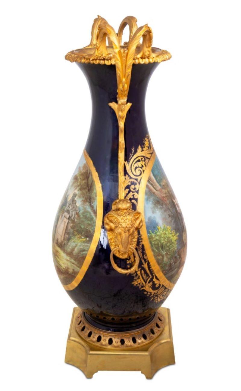 Vaso ovoidale a due manici in porcellana di Sèvres con fondo blu e metallo dorato, fine XIX secolo, con montatura a testa di ariete, corpo dipinto con una scena romantica dal titolo  