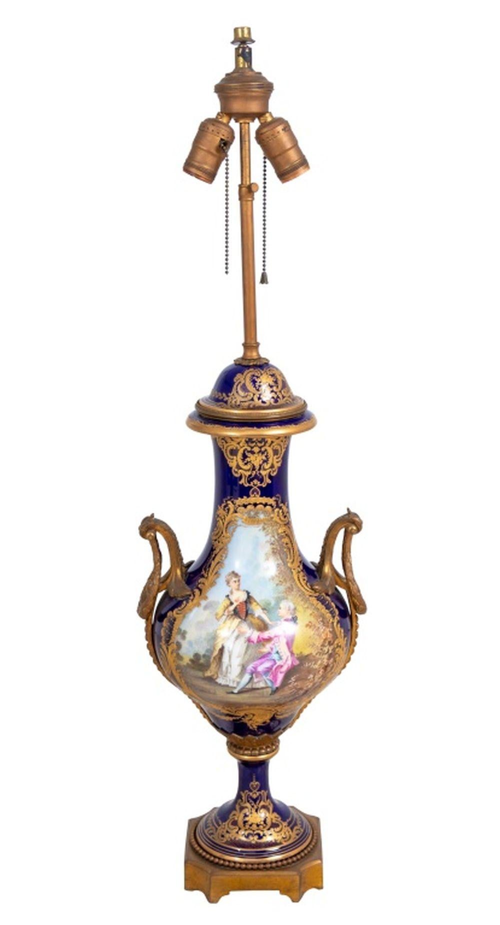 Vase à deux anses en porcelaine monté en métal doré sur fond bleu Sèvres et monté en lampe, début du 20e siècle, le corps peint d'une scène d'un couple se faisant la cour, signé 