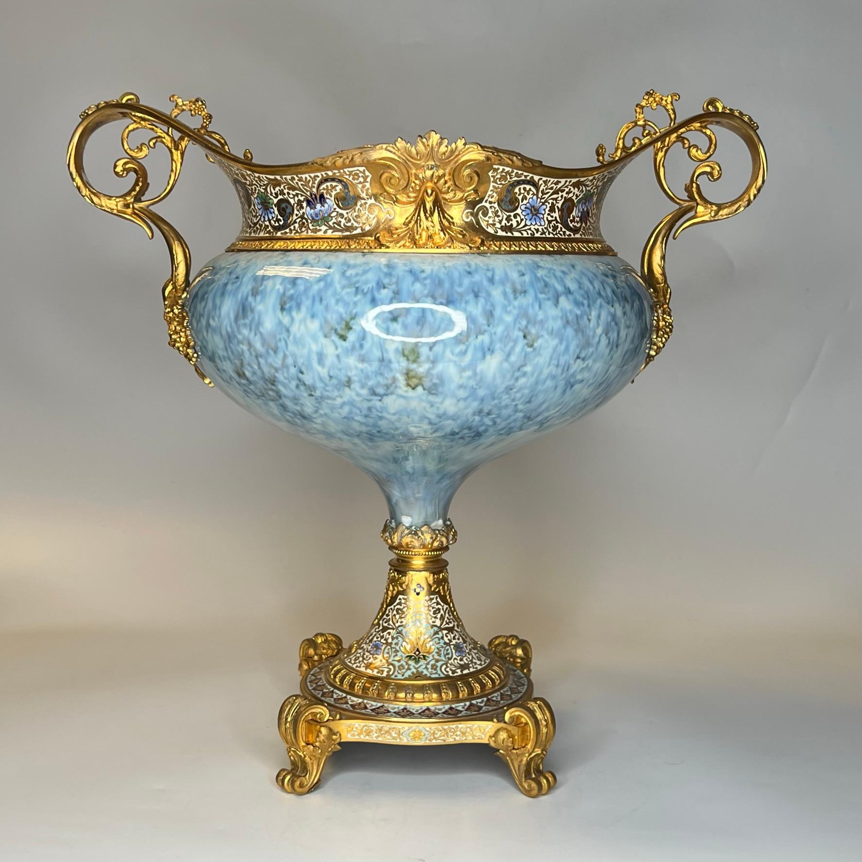 Unsere außergewöhnliche Schale aus Porzellan mit Fuß aus dem 19. Jahrhundert mit schöner eierschalenblauer Glasur, die Sèvres zugeschrieben wird, hat einen vergoldeten Bronzesockel, Henkel und Rand und ist mit einer schönen Emailleeinlage versehen.  