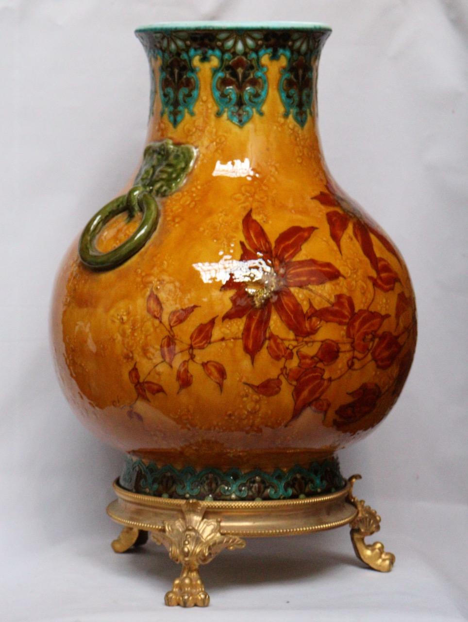 Optat Milet (1838-1911) Sèvres
An Aesthetic Mouvement Ormolu-Mounted and Faïence Vase 
Polychromed Enamelled Faïence designed with bunch of flowers on an orange gold ground
On an three pawn feet gilt bronze base
Signed on the body Emile Diffloth