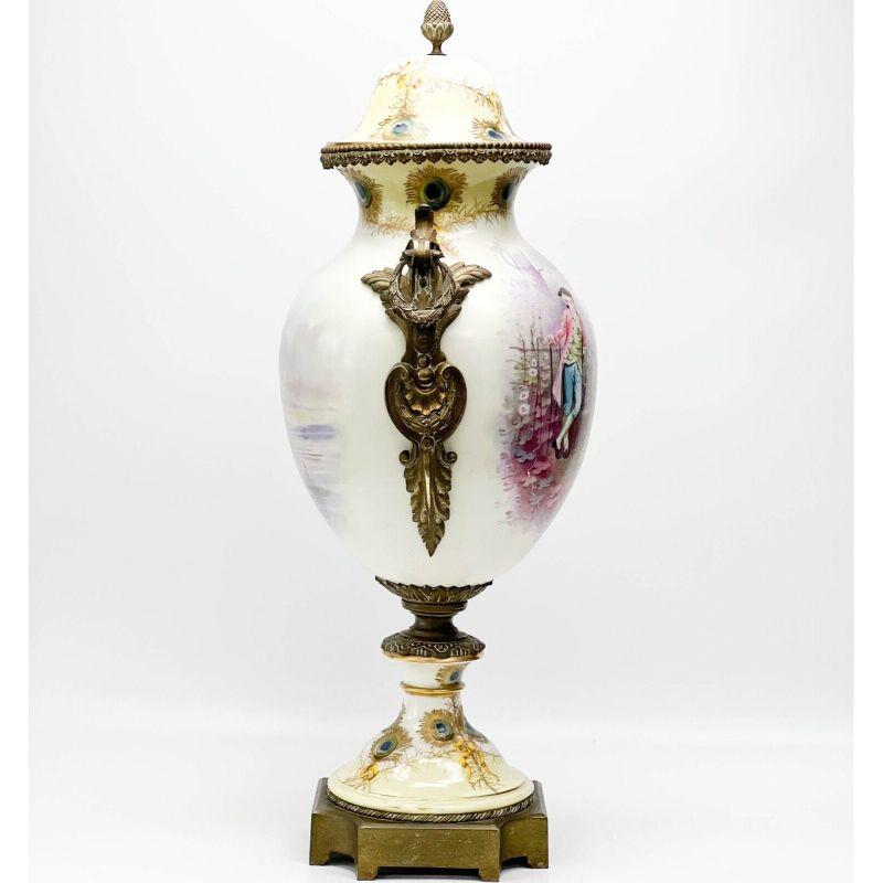Sevres France Hand Painted Porcelain Bronze Mounted Large Covered Urn

Sevres France hand painted porcelain bronze mounted large covered urn, 4th quarter 19th century. Hand painted image to one side featuring 3 figures, one playing music while the