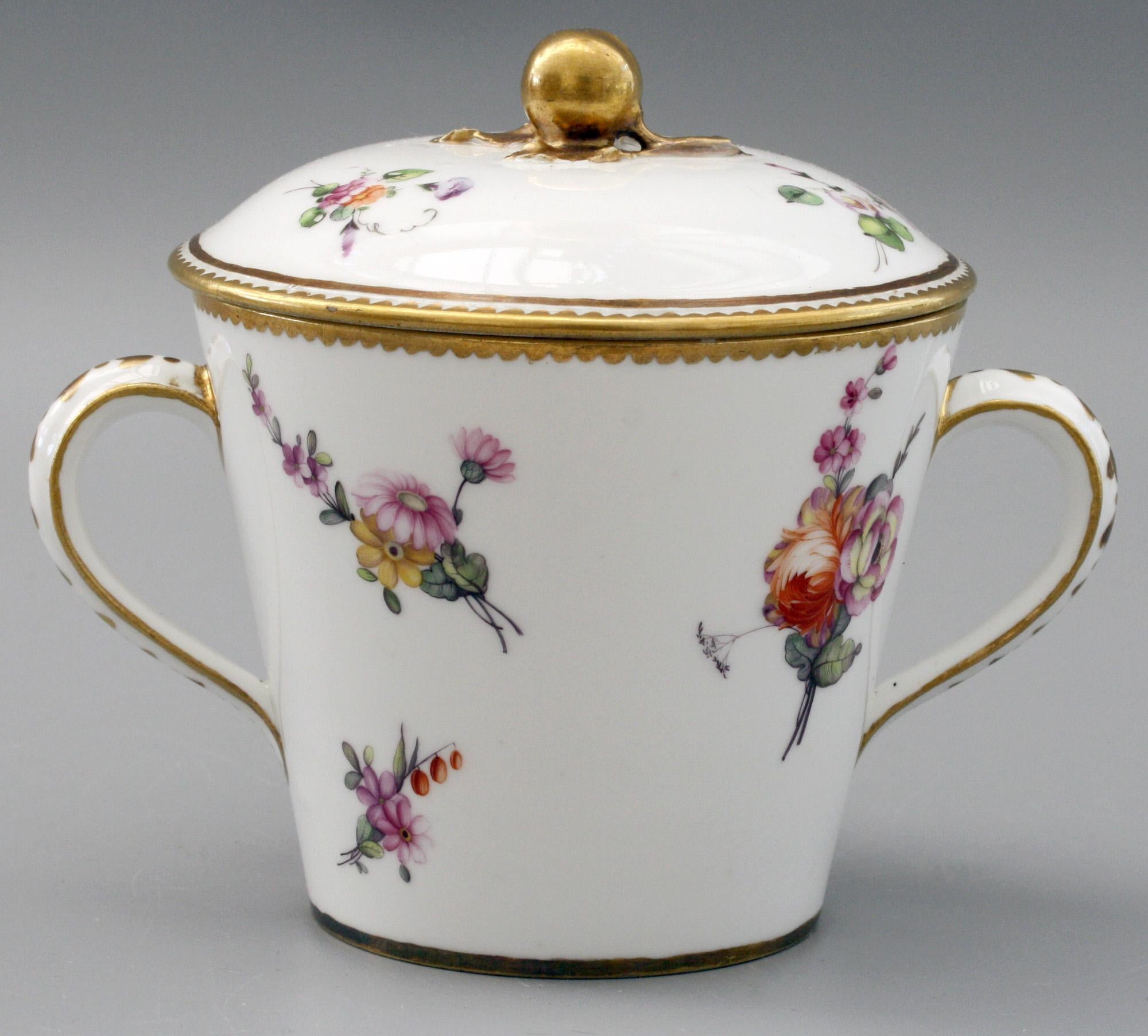 An exceptional three part antique French Sèvres porcelain twin handled lidded chocolate cup with large saucer stand hand painted with flowers by Dusolle (1768-1774) and date marks for 1772. The conical shaped cup is applied with ear shaped handles