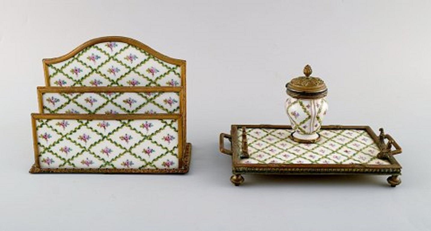 Sevres / Limoges style. Desk garniture in hand painted porcelain and brass. Early 20th century. Paperweight, letter holder, ink well, ink cleaner, pen tray, etc.
Paperweight measures: 17 x 13 cm
The ink well measures: 21 x 12 cm.
In very good