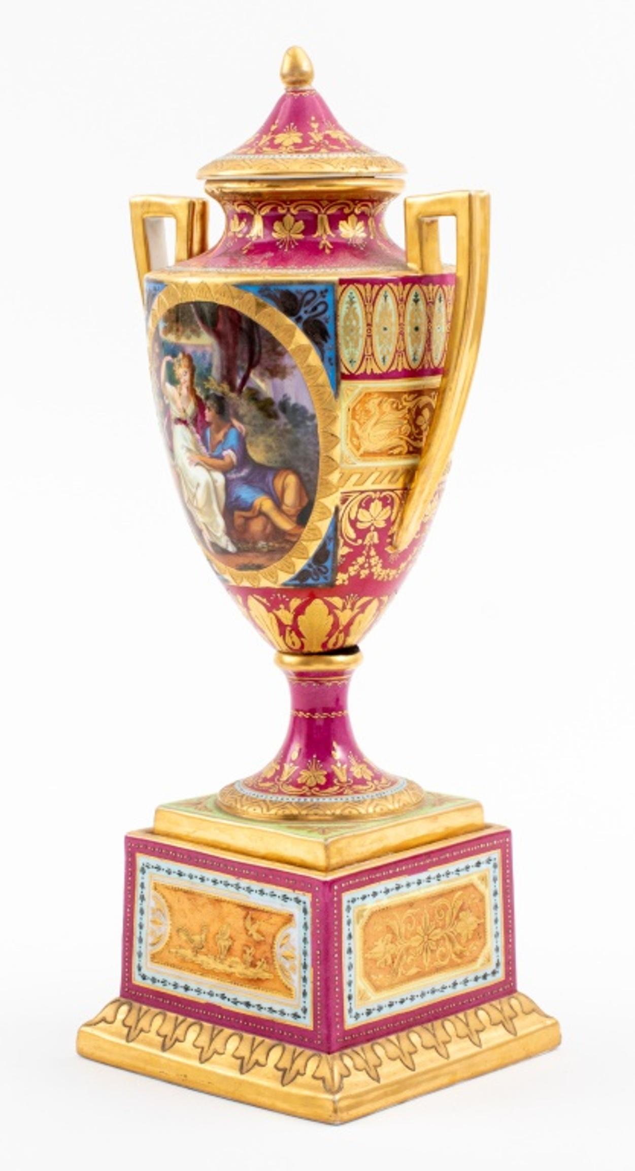 Vase urne rose à la manière de la porcelaine de Sèvres richement décorée de détails dorés, deux anses, un capuchon, représentant une scène extérieure, marqué à la base. Objet vintage en très bon état. 
Concessionnaire : S138XX