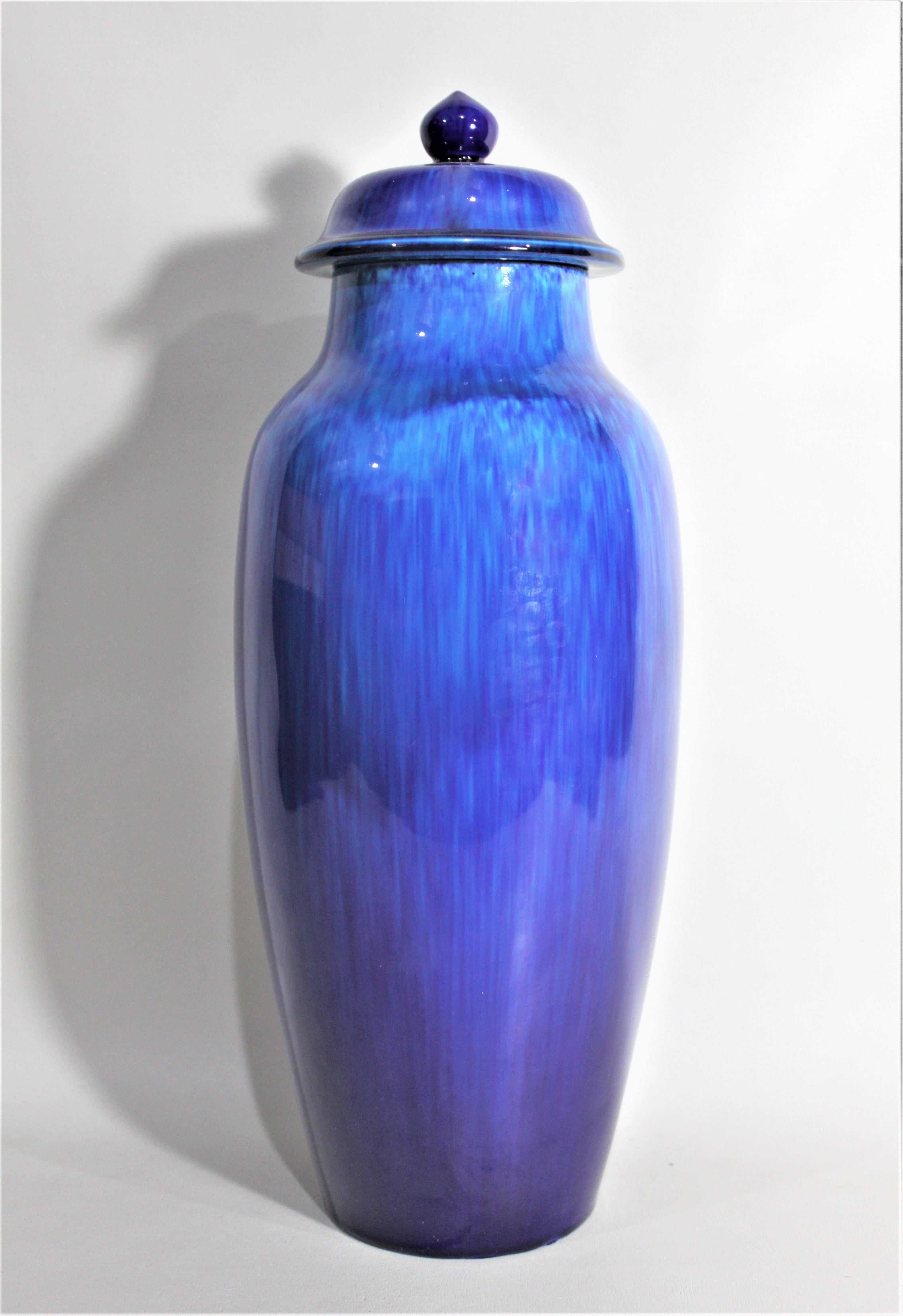 Ce grand vase à couvercle bleu cobalt a été fabriqué par la fabrique de poterie de Sèvres en France et conçu par l'artiste Paul Milet vers 1935. Cette urne en céramique lourde est faite d'une glaçure brossée bleu cobalt profond sur turquoise avec un