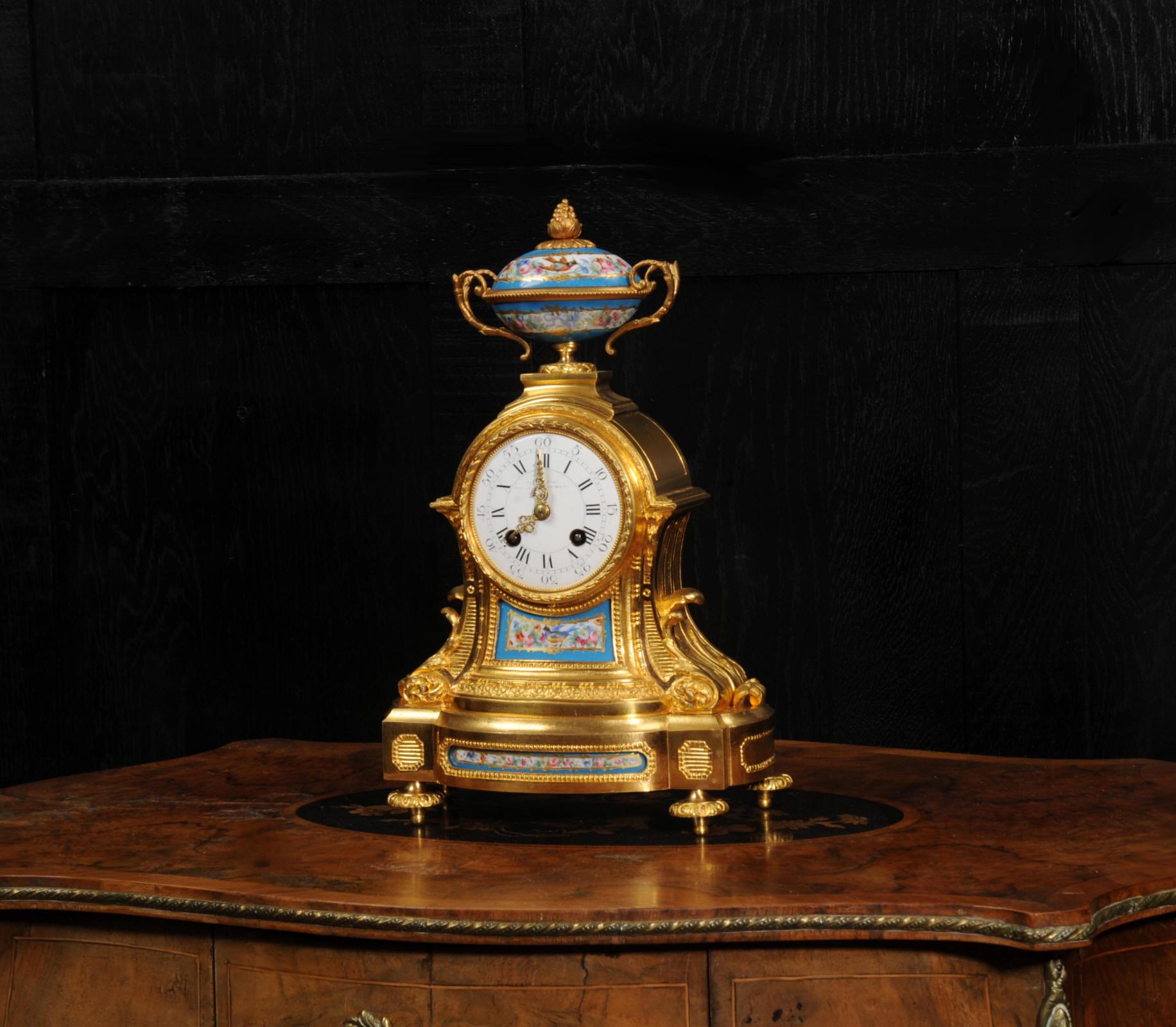 A superb early antique French ormolu and Sèvres style porcelain clock. It is made of exquisite ormolu (finely gilded bronze) mounted with very finely painted Sèvres style porcelain, exotic birds and flowers, with a blue ground. It is by the Parisian