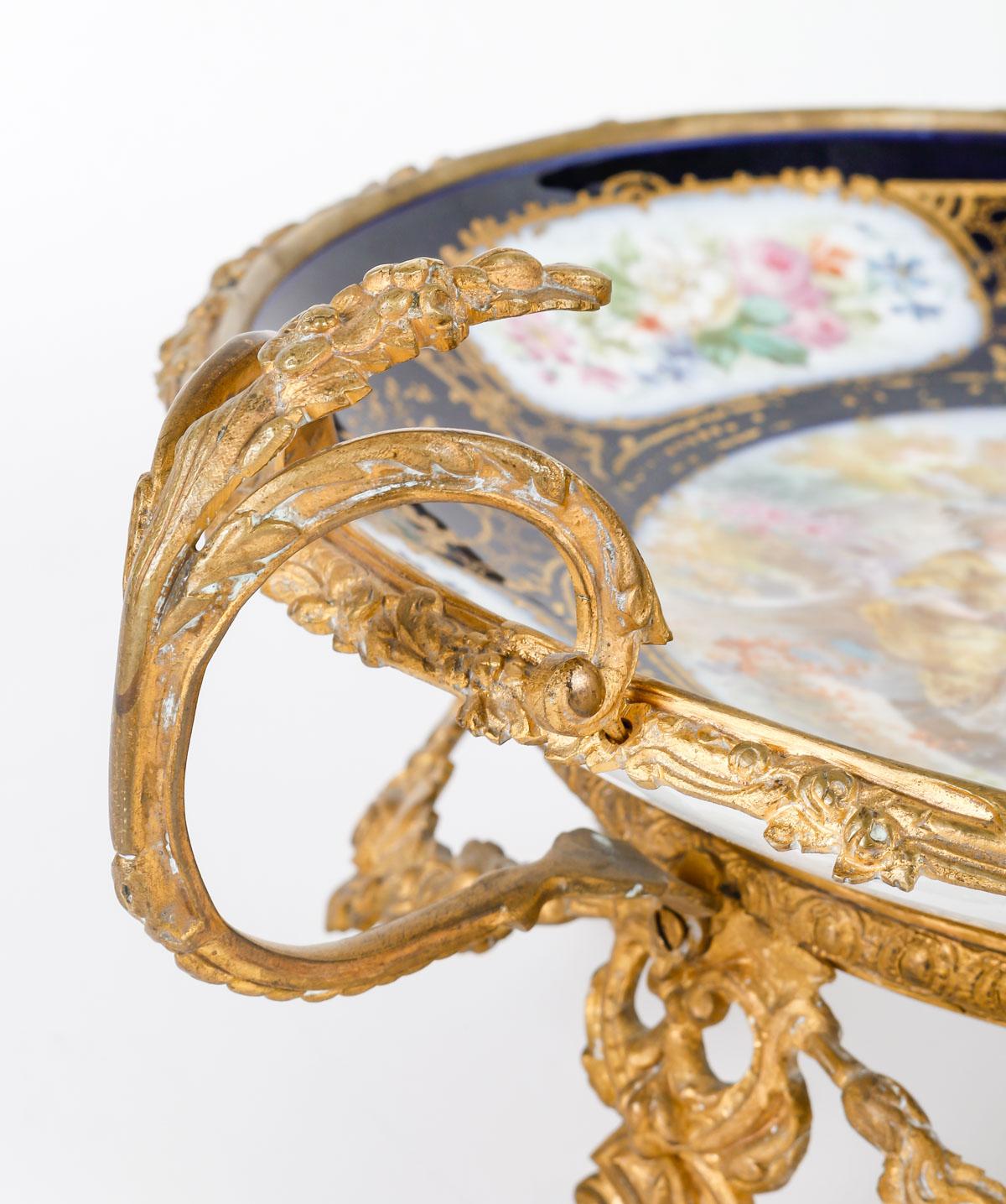 Sèvres Porzellantasse und vergoldete Bronzemontierung, Napoleon III.

Porzellanschale aus Sèvres, 19. Jahrhundert, mit vergoldeter Bronzemontierung, Periode Napoleon III.
h: 17cm, l: 37cm, p: 30cm

