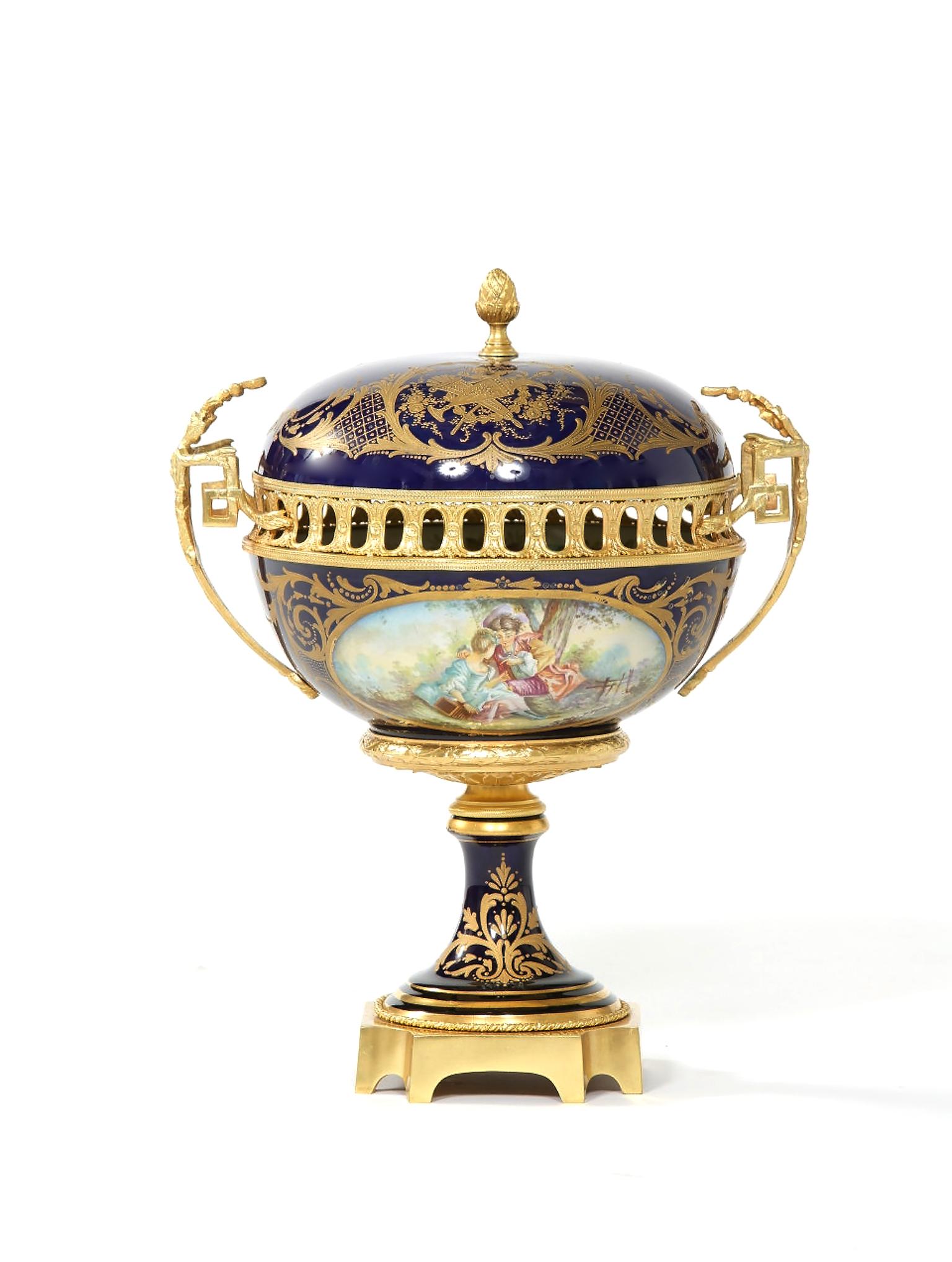 Sevres cobalt blue with gilt bronze mounted framed covered decorative piece with Interior / exterior hand painted details. The centerpiece is in great condition with wear consistent with age / use. Maker's mark undersigned. The piece stand about 18