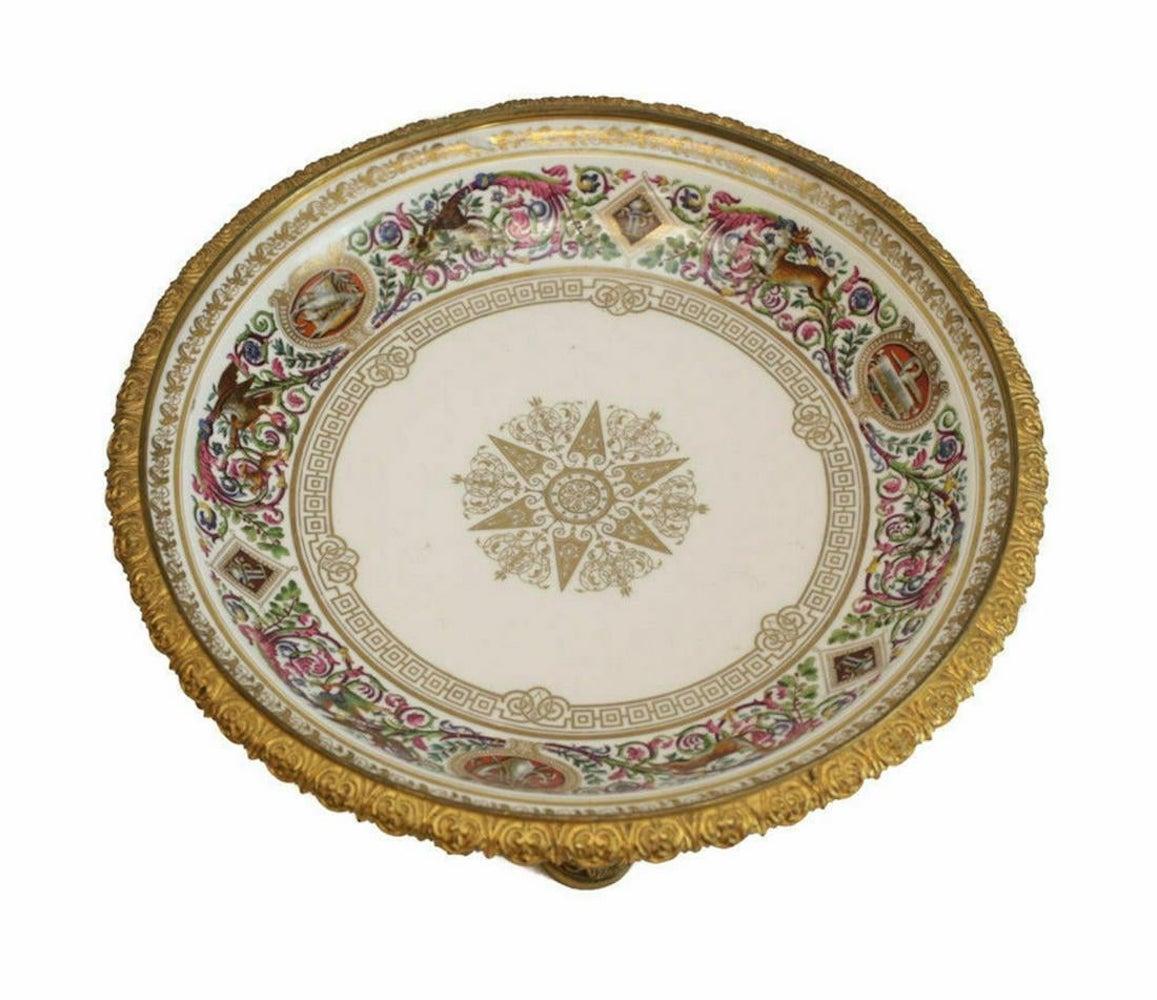 Manufacture National de Sevres porcelain and gilt bronze centerpiece bowl, in the Louis Philippe Chateau de Fontainebleau pattern, dated for 1852. Various hand painted hunting scenes of woodland creatures along with alternating armorial crests and