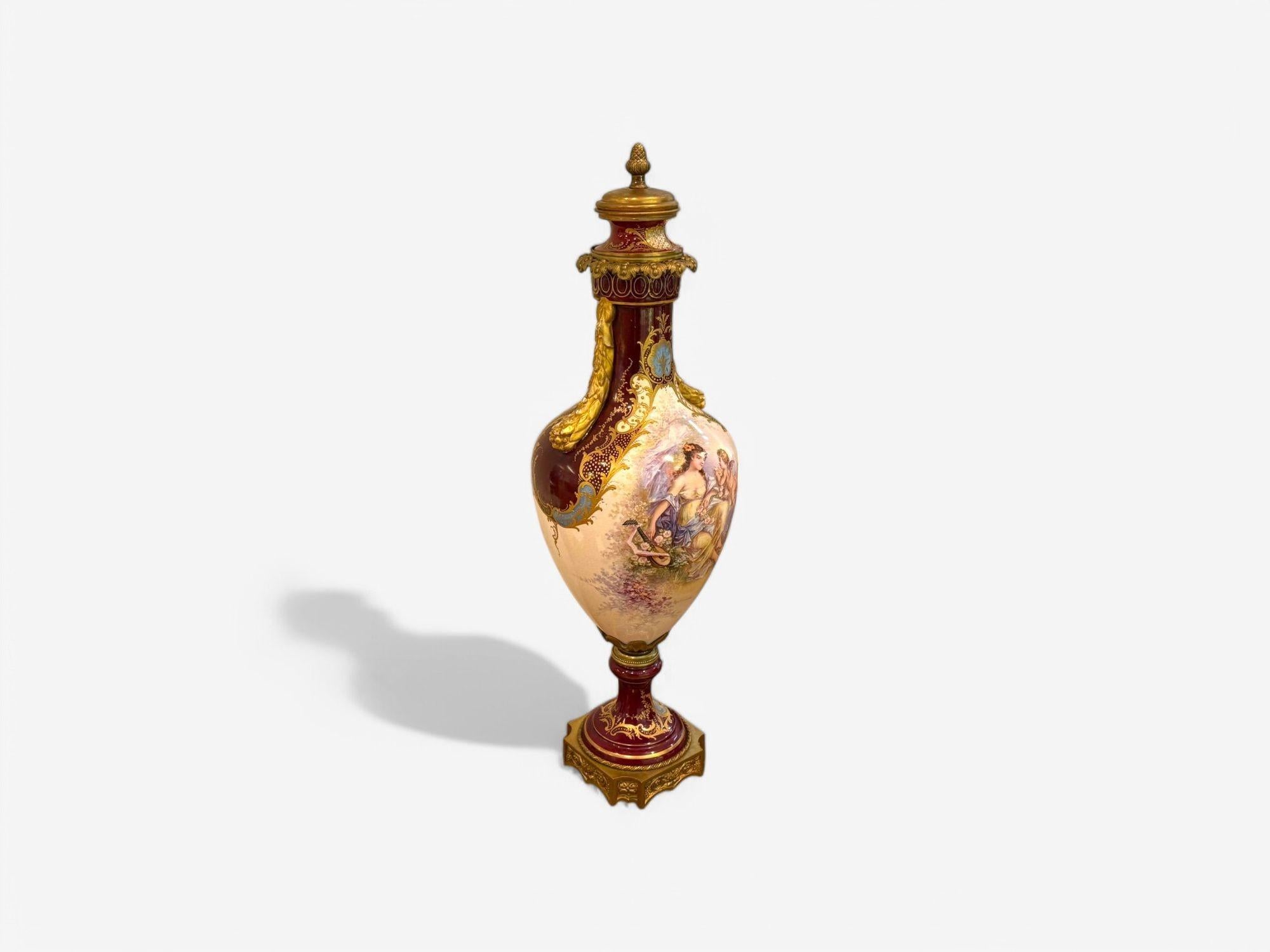 Vaso a due manici di Sèvres con fondo borgogna e metallo dorato con coperchio abbinato

Questo vaso di forma ovale presenta un Cherubino e una Fanciulla seduti in un bellissimo paesaggio racchiuso da eleganti bordi dorati. Il rovescio del vaso