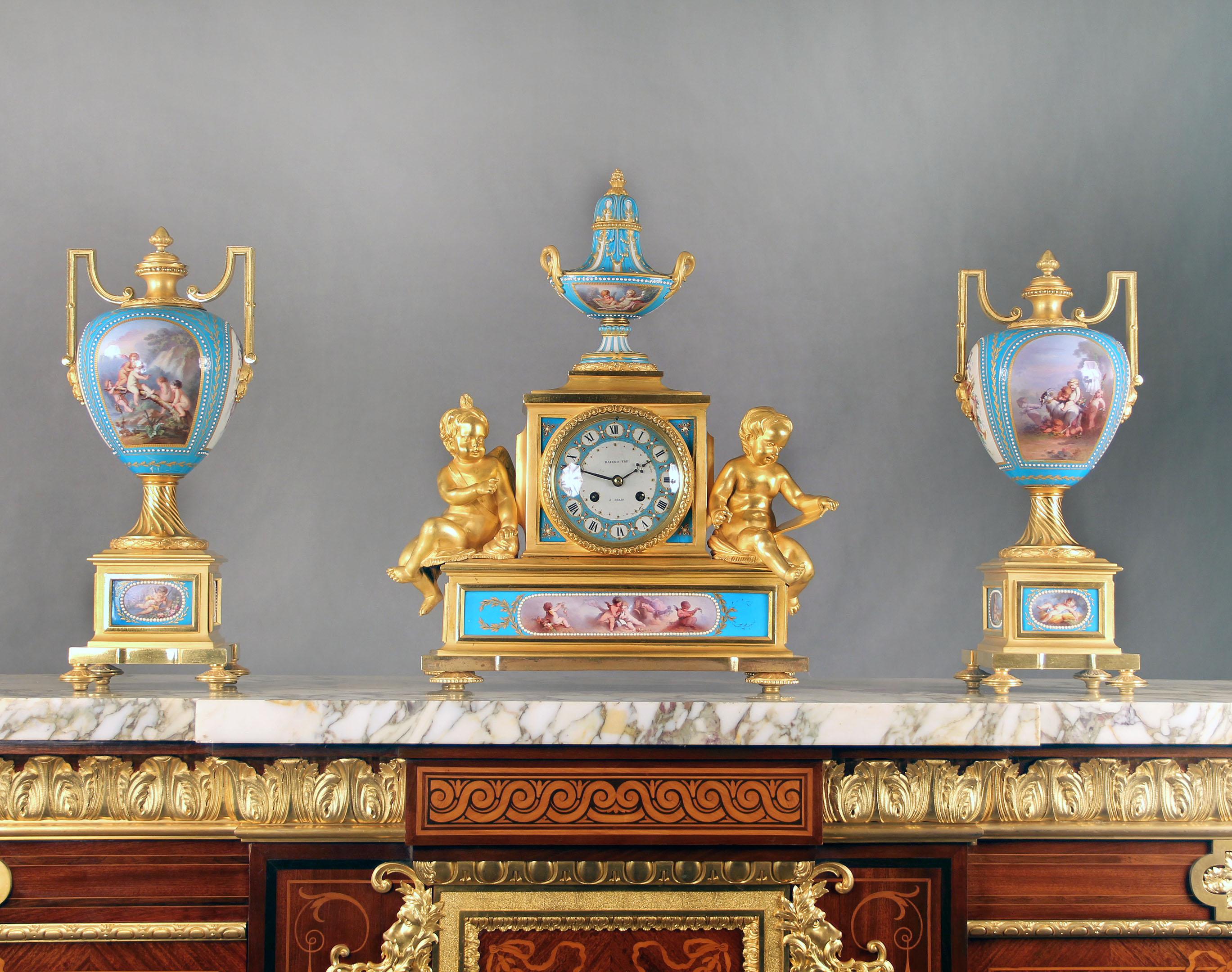 A wonderful and important mid-19th century gilt bronze and turquoise sevres porcelain 'Jeweled' three-piece clock set.

By Raingo Frères.

The clock surmounted by a covered urn with gilt porcelain handles, the clock face signed Raingo Fres A