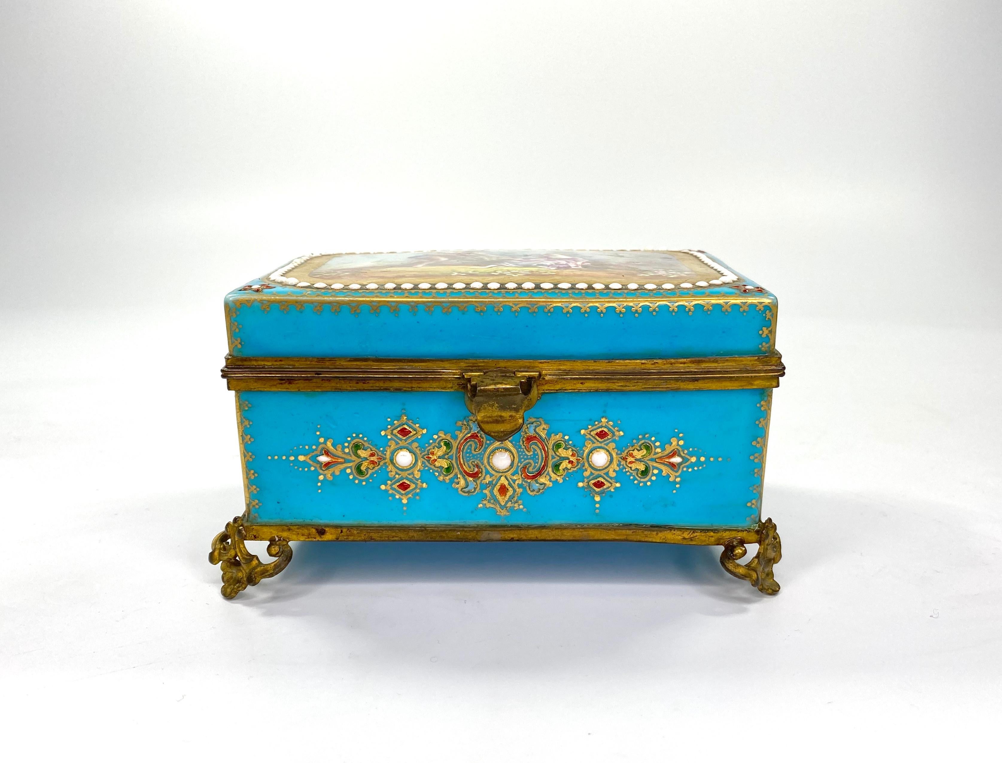 A fine ‘Sèvres’ porcelain ‘Jewelled’ casket, with ormolu mounts, circa 1880. The rectangular casket, well painted to the cover, with a scene of rustic lovers, wearing 18th century costume, in a garden setting, within a tooled gilt, and white enamel