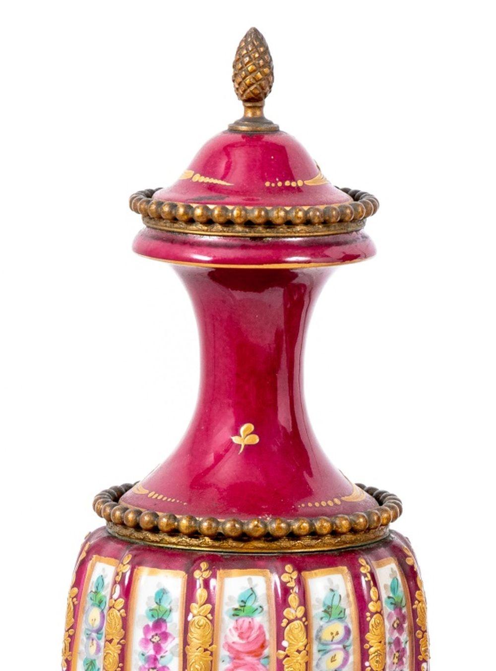 Coppia di vasi montati in metallo dorato di Sèvres Rose du Barry, fine del XIX secolo, ciascuno con la parte superiore a cupola e il corpo a spirale dipinto con volute floreali ed elaborati bordi dorati su una base di metallo dorata e socle, con il