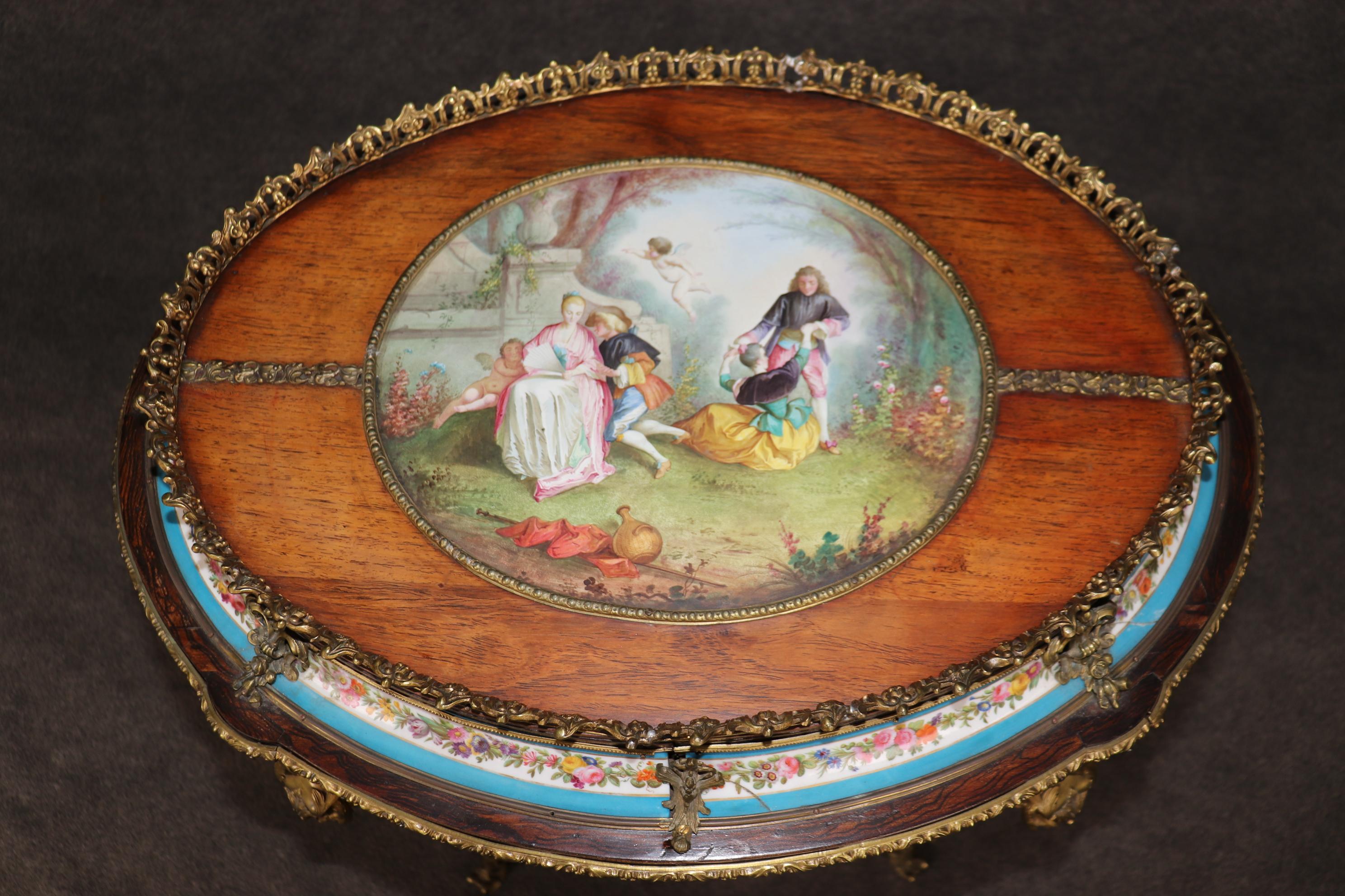 This is a wonderful, extremely elaborate Sevres style plaque encrusted and bronze mounted walnut table. The table is in good antique condition and features incredible porcelain plaques and is does have one minor crack in one plaque as shown. The