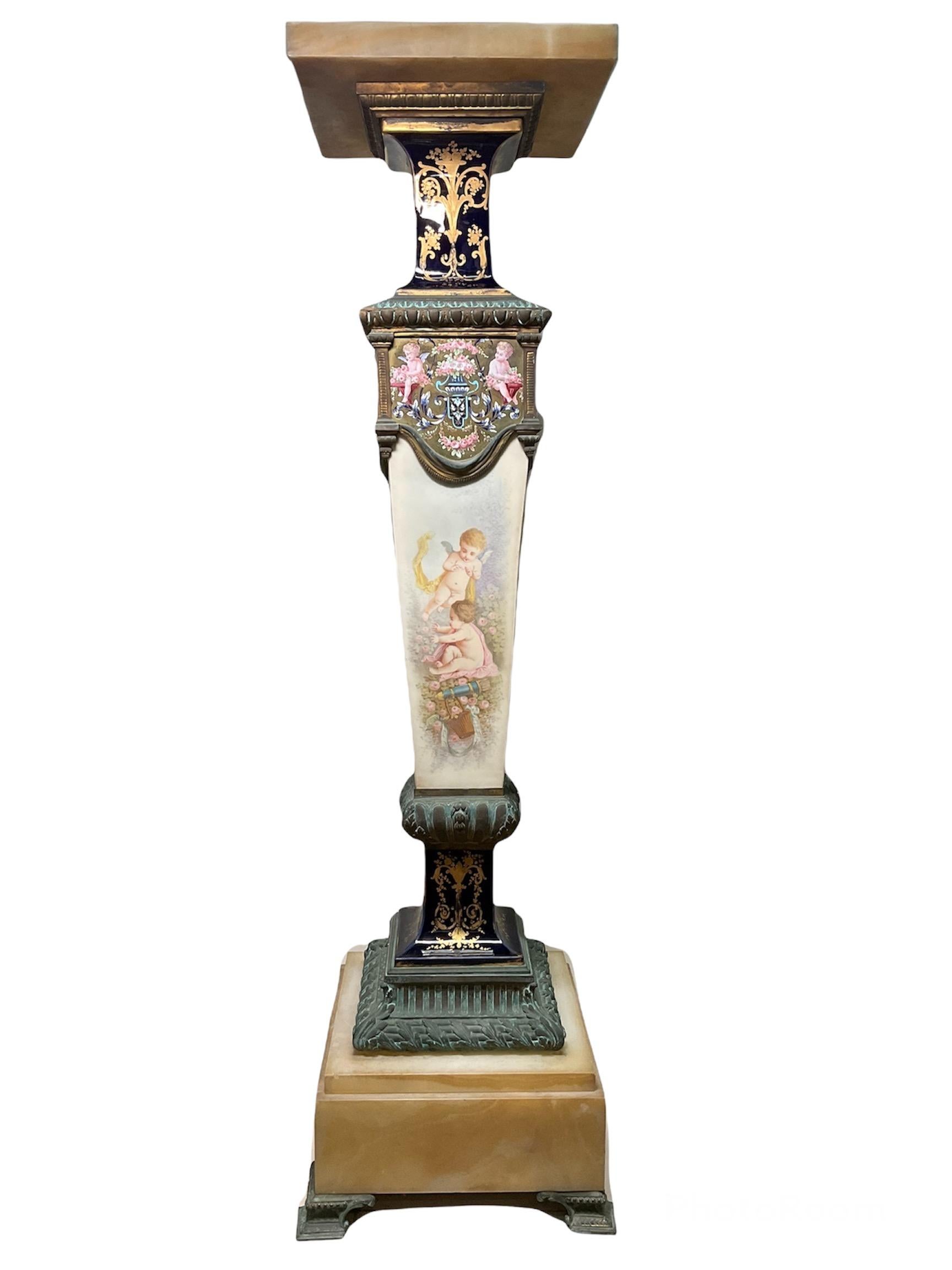 This is a Sevres Style onyx, bronze and hand painted porcelain pedestal. The pedestal consists of eight pieces. The first piece is the onyx square top followed by the second piece that is a bronze square base. Then come a long square gilt cobalt