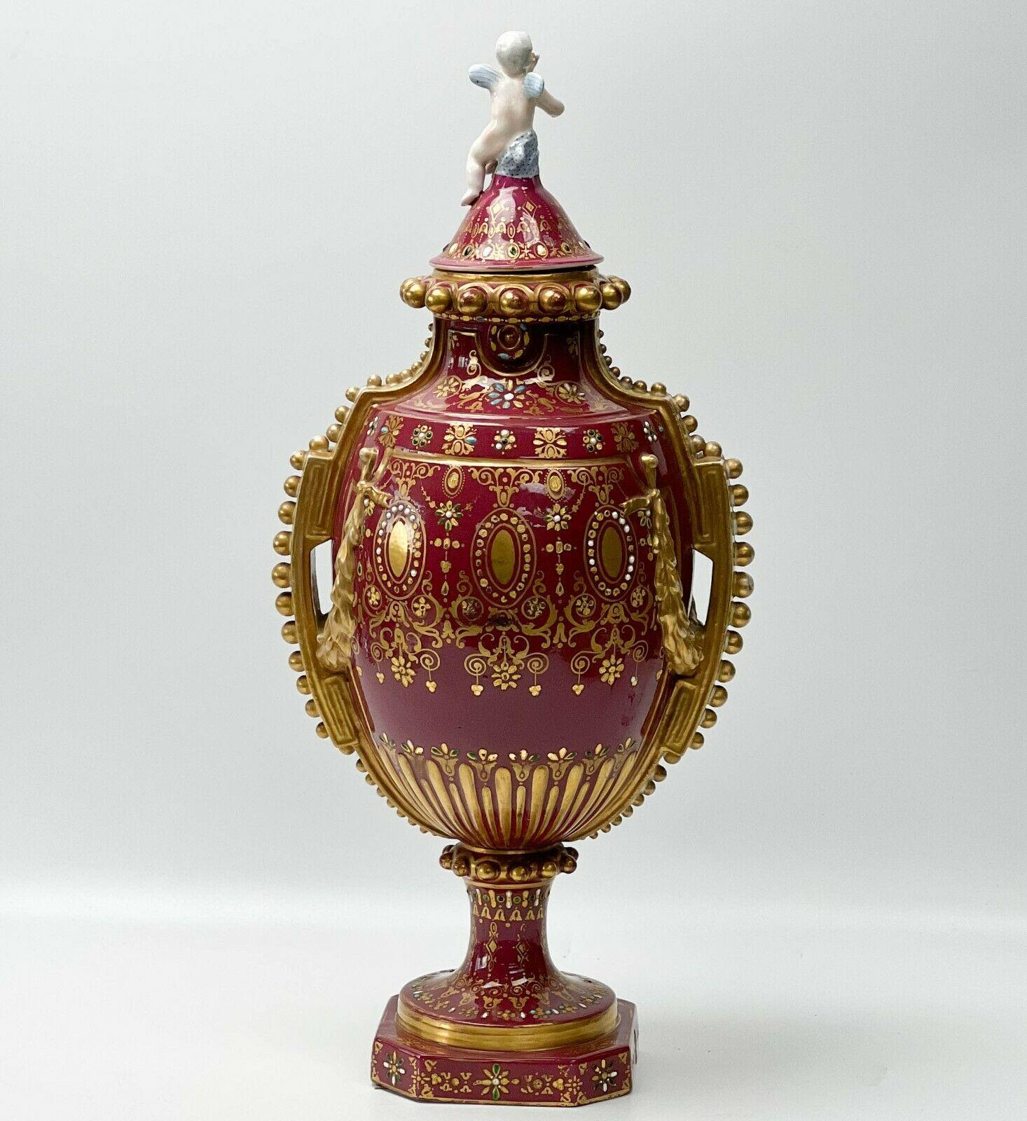 Urne couverte à deux anses en porcelaine de Sèvres peinte à la main, vers 1900

Un fond de couleur magenta profond avec une décoration de guirlande dorée en relief, des motifs dorés élaborés tout autour avec des décorations en émail turquoise,