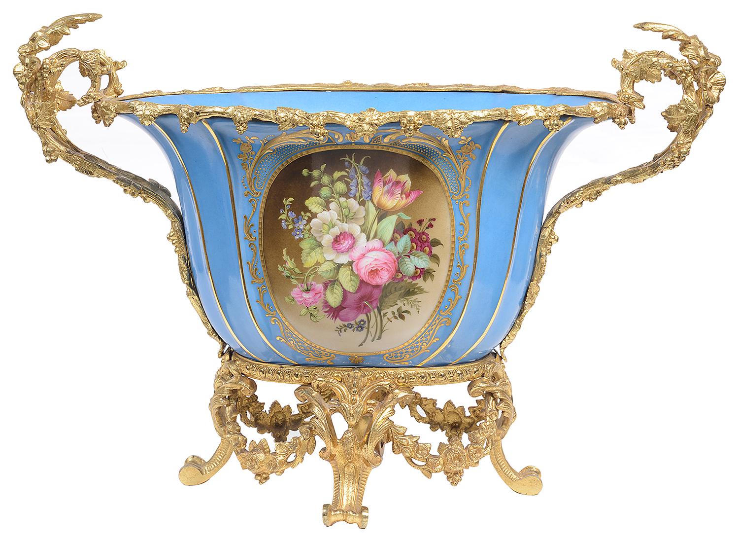A good quality French 19th century 'Sevres' style porcelain and gilded ormolu jardinière, the handles to either side and rim of grape vine form, the fluted porcelain bowl with gilded decoration, oval inset painted panels with colourful flowers,