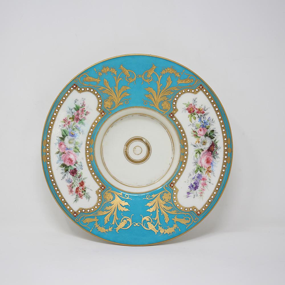 French Sevres bleu celeste ground lidded chocolate cup and saucer circa 1880. The set jewel encrusted with beautiful floral scenes amongst gilt scrollwork with a central seated cherub. The cup with an interlaced gilt striped handle with white glaze
