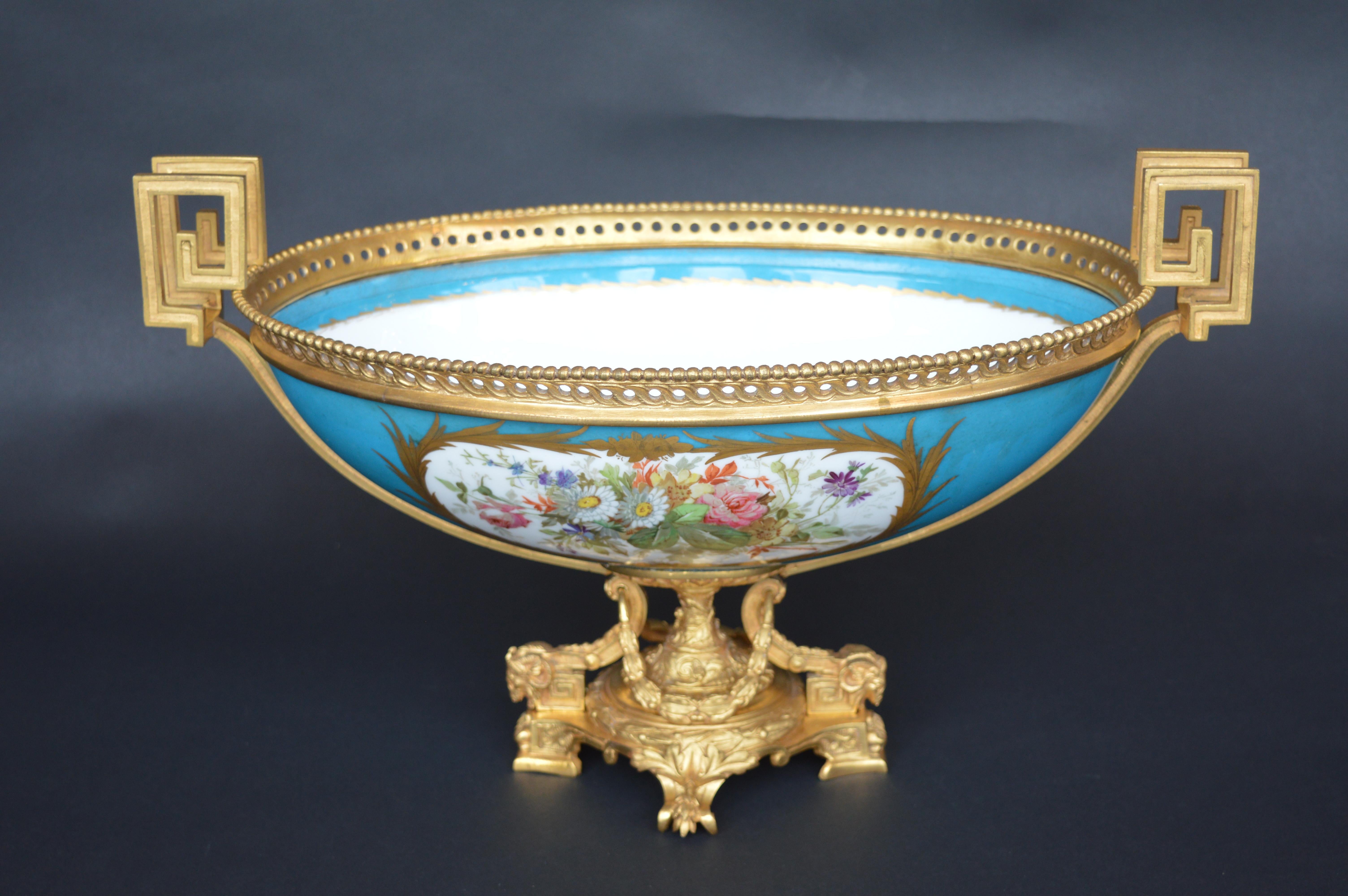 A sèvres style parcel-gilt ormolu-mounted enameled blue celeste porcelain center bowl, last quarter of the 19th century, the rim mounted with bead and reticulated guilloche motif, over reserves, one painted with a Native American hunt scene