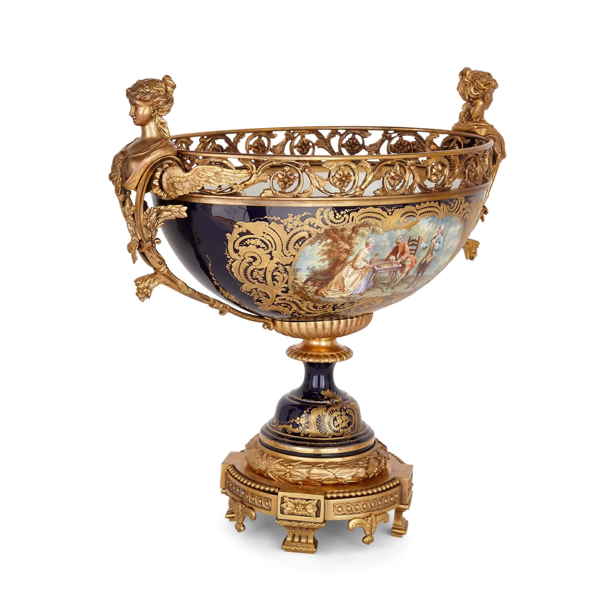 Suite di porcellana e vasi da guarnizione in stile Sèvres, in porcellana e bronzo dorato
Francese, fine del XIX secolo
Misure: Vasi: altezza 72 cm, larghezza 36 cm, profondità 22 cm.
Urna: altezza 53cm, larghezza 56cm, profondità 29cm

Questa
