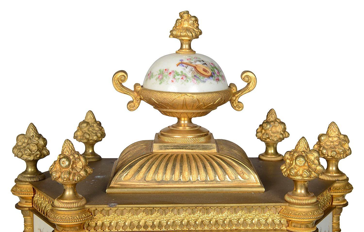 A fine quality late 19th Century French gilded ormolu mantel clock with hand painted Sevres style porcelain plaques, depicting beautiful maidens. Having a porcelain lidded urn to the top, six gilded fruit like finials, a porcelain painted clock face