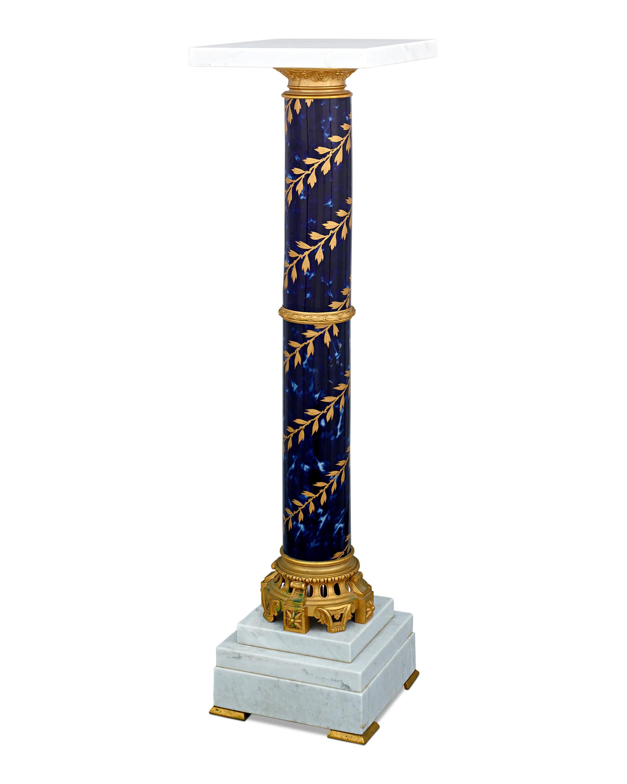 This pedestal exhibits the style and grace of the famed Sèvres porcelain manufactory. Its lustrous deep blue porcelain base is Classic Sèvres in style, and it provides the perfect background for the intricate gilt neoclassical motif that encircles