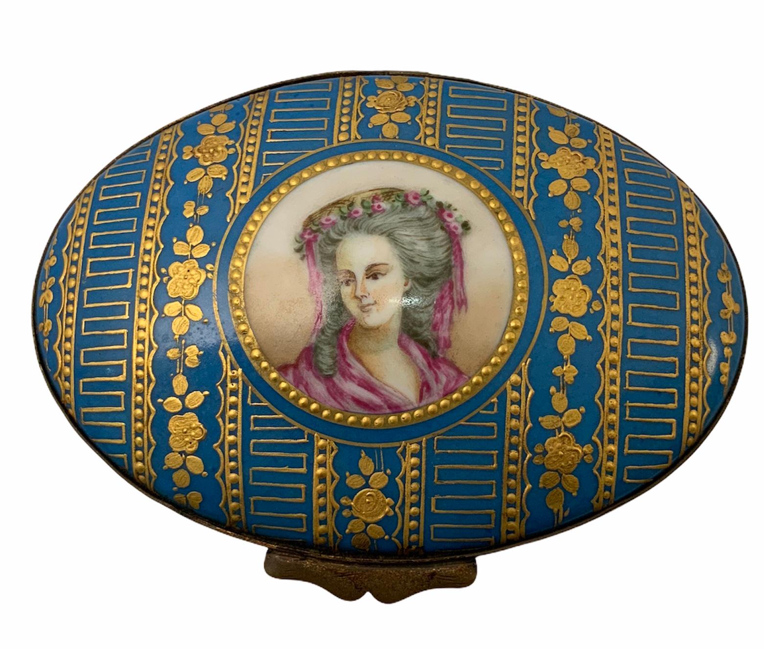 This is a rare, wide, tall & oval chest box hand painted turquoise. Adorned with a garland of gilded flowers alternated by Greek lines. In the center, there is a round portrait of a lady framed by gold beads. Inside, there are some hand painted