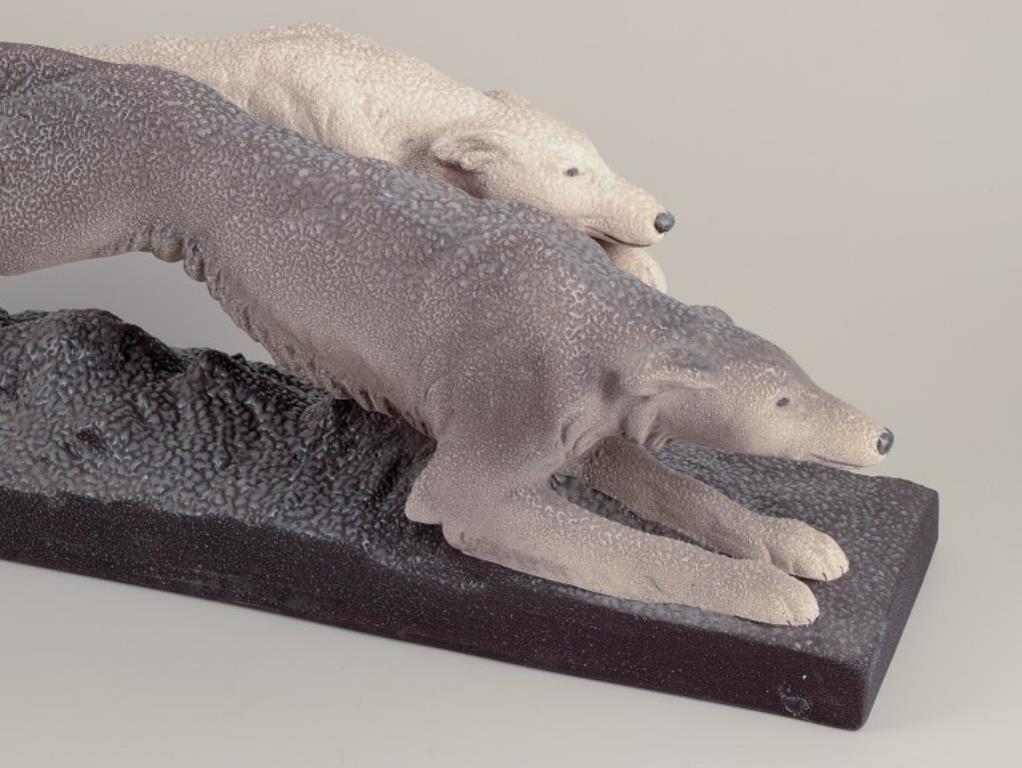 Sèvres Vinsare, Francia.
Colossale scultura in ceramica di due levrieri in corsa. Art Déco.
Smalto grigiastro e color sabbia.
Circa 1930.
Contrassegnato.
In ottime condizioni, piccola e insignificante scheggiatura alla base del piedistallo. Vedi
