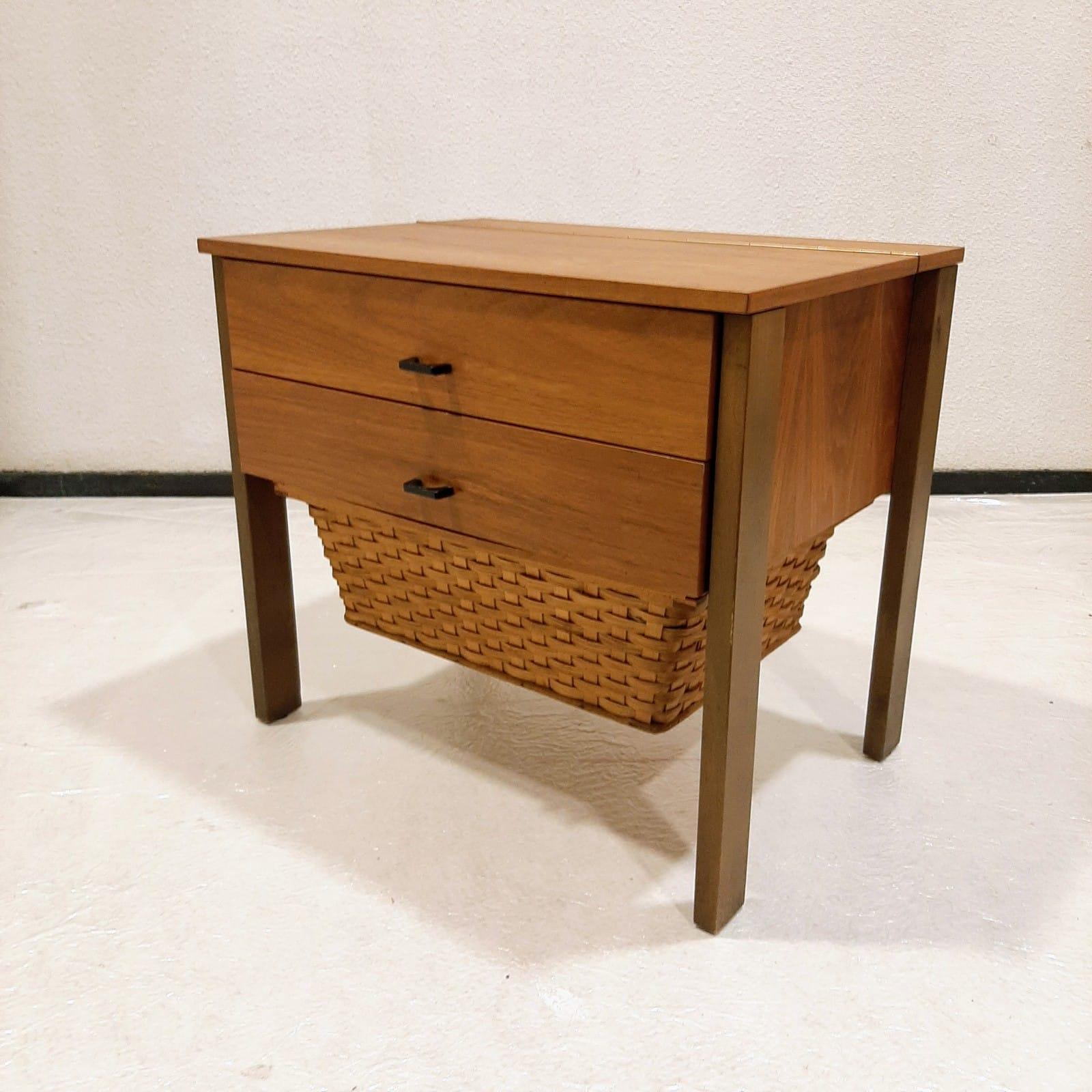 Magnifique meuble de couture qui peut également servir de table de nuit.

Il comporte deux tiroirs qui s'ouvrent en douceur. La partie supérieure sert également de porte à charnière.

Le panier en roseau est élégamment centré entre les quatre