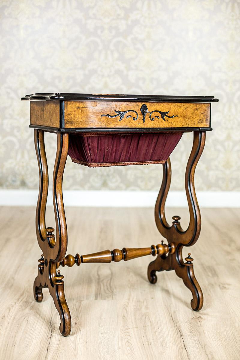 We present you this sewing table in birchen burl.
The apron is rectangular, placed on two openwork supports that are finished with a volute, and connected with a cross bar.
There is a drawer in the shape of a reversed trapezoid under the