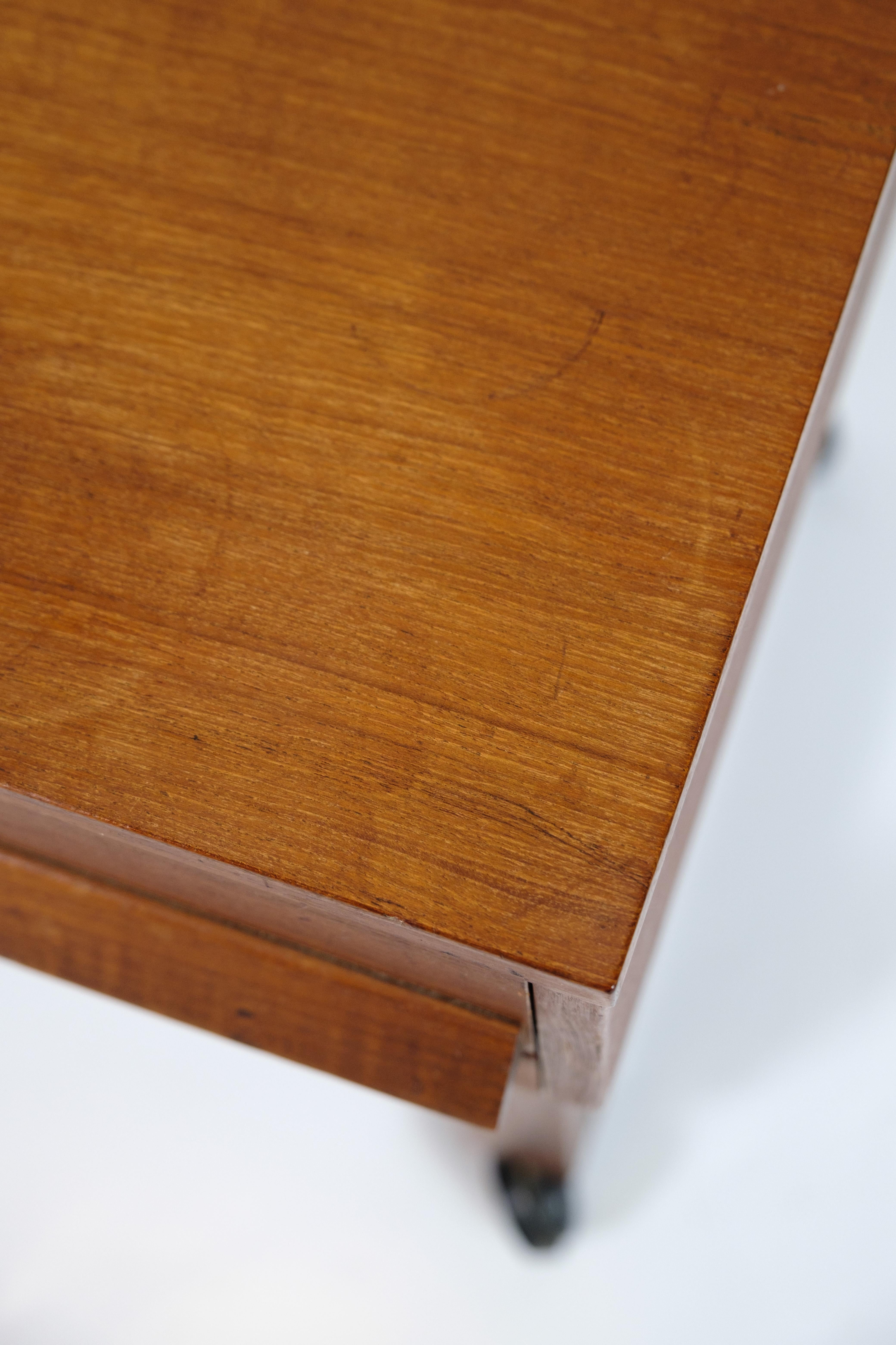 Table de couture en Teak Classics avec tiroir et roulettes, fabriquée selon le design danois classique des années 1960. La table est pratique et comporte un tiroir spacieux pour ranger les accessoires de couture ou d'autres petits objets. Elle est