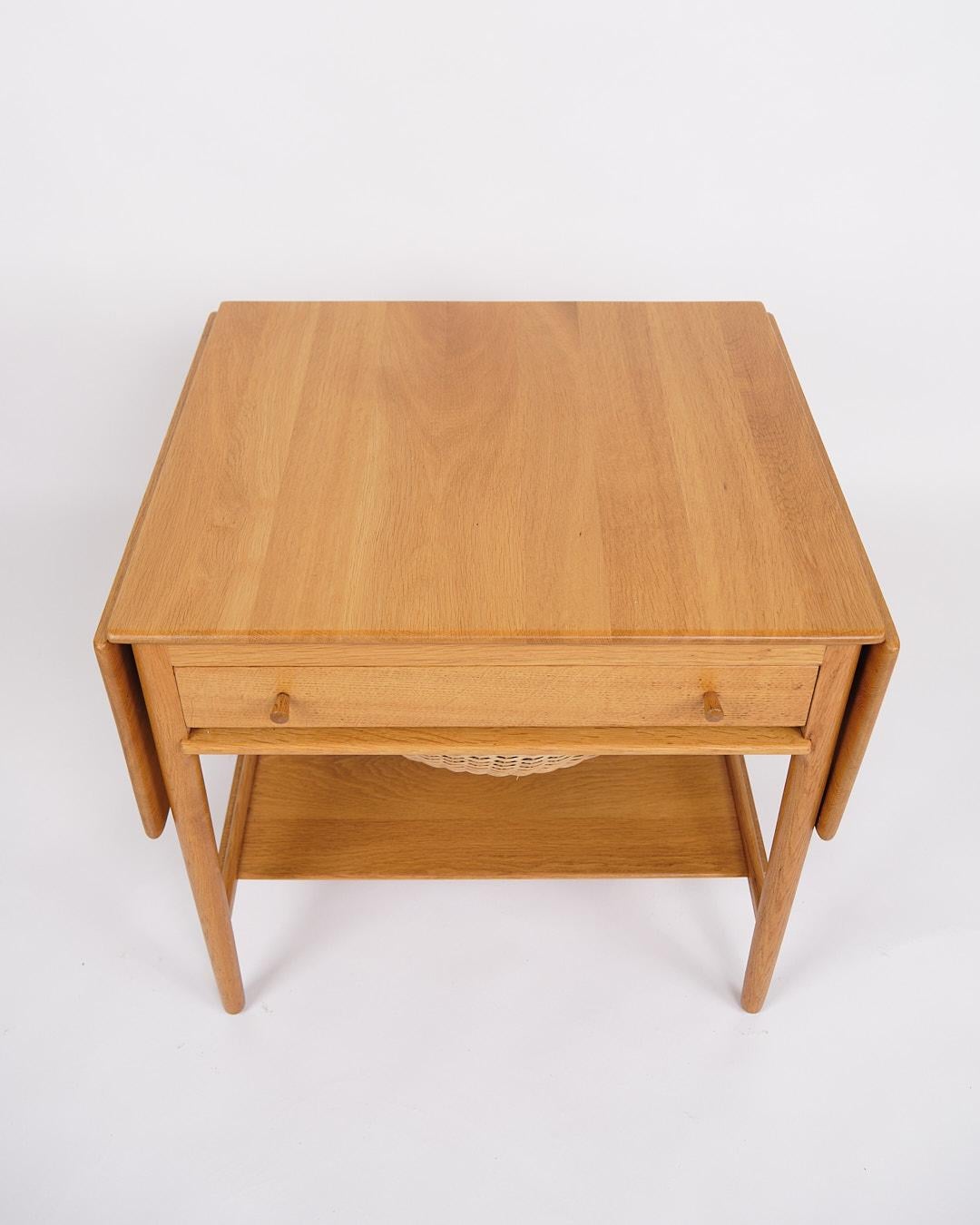 Sewing table, model AT-33, designed by Hans J. Wegner and produced by Andreas Tuck in the 1950s. The table is made of soap-treated oak and equipped with a practical shelf. The tabletop can be extended from 64.5 cm to 118.5 cm, making it both