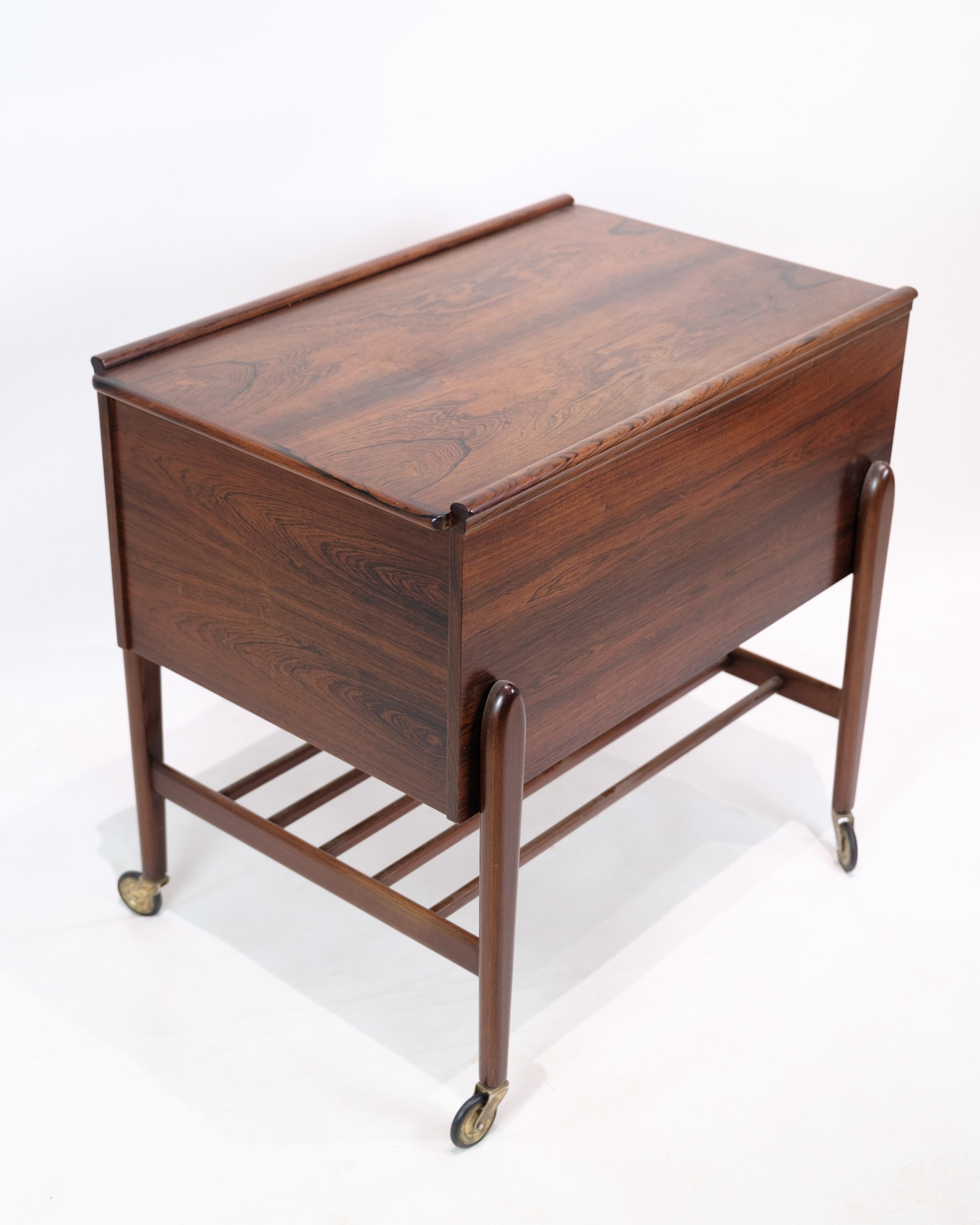 Sewing table with wheels in rosewood from the 1960s. The table has a practical built-in drawer for storing sewing accessories and is made of materials that ensure good durability. The wheels make the table easy to move around, increasing its