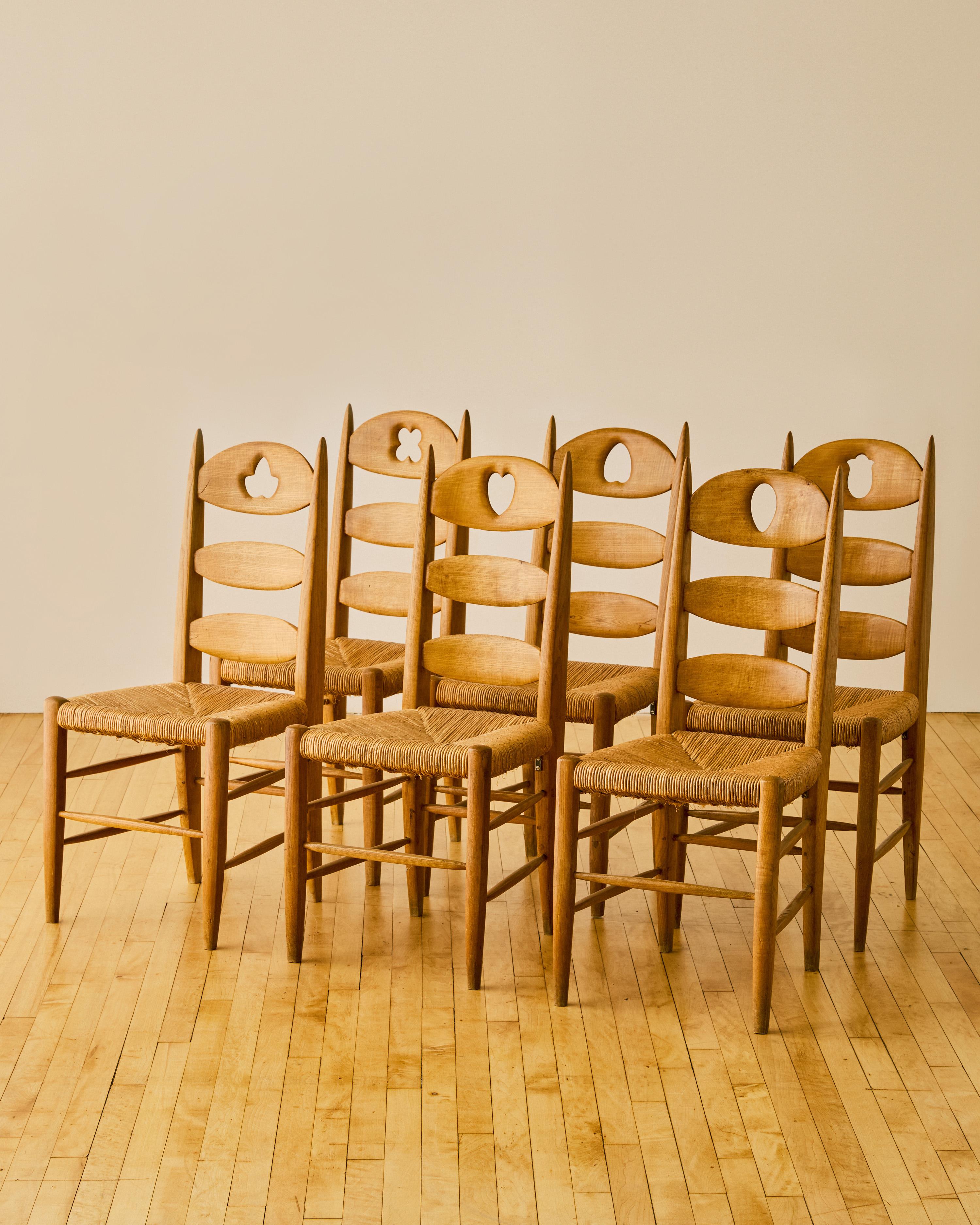 Set of six French carved back dining chairs C. 1960's. Crafted in Ash wood with rattan seating, each of these chairs have a unique carving design along the backrest.