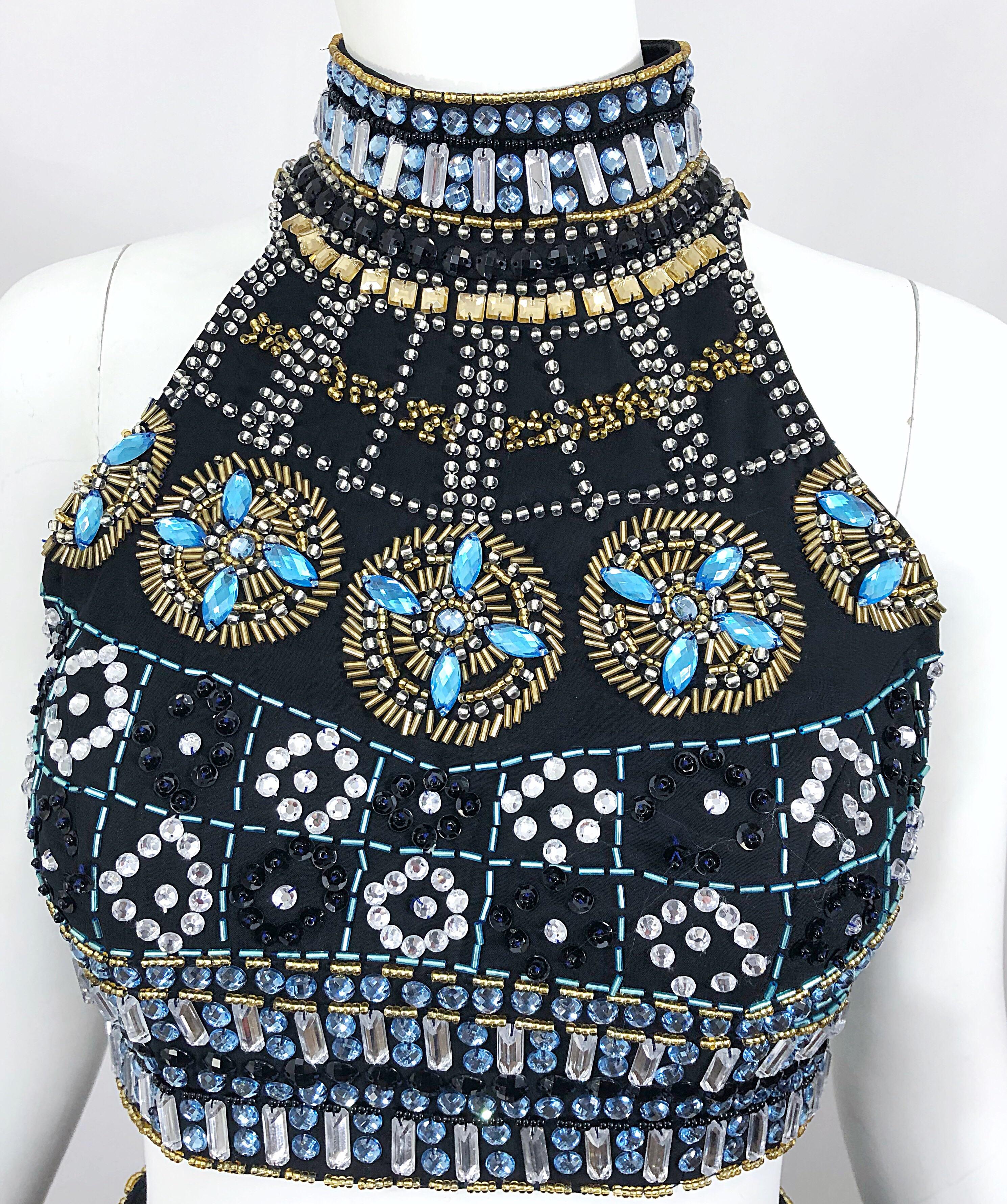 Sexy 1990s black chiffon beaded crop top and trained maxi skirt caged gown ensemble! Features turquoise blue, gold, silver and black beads throughout, along with rhinestones. Low rise skirt has a 
peek-a-boo in the back that reveals just the right
