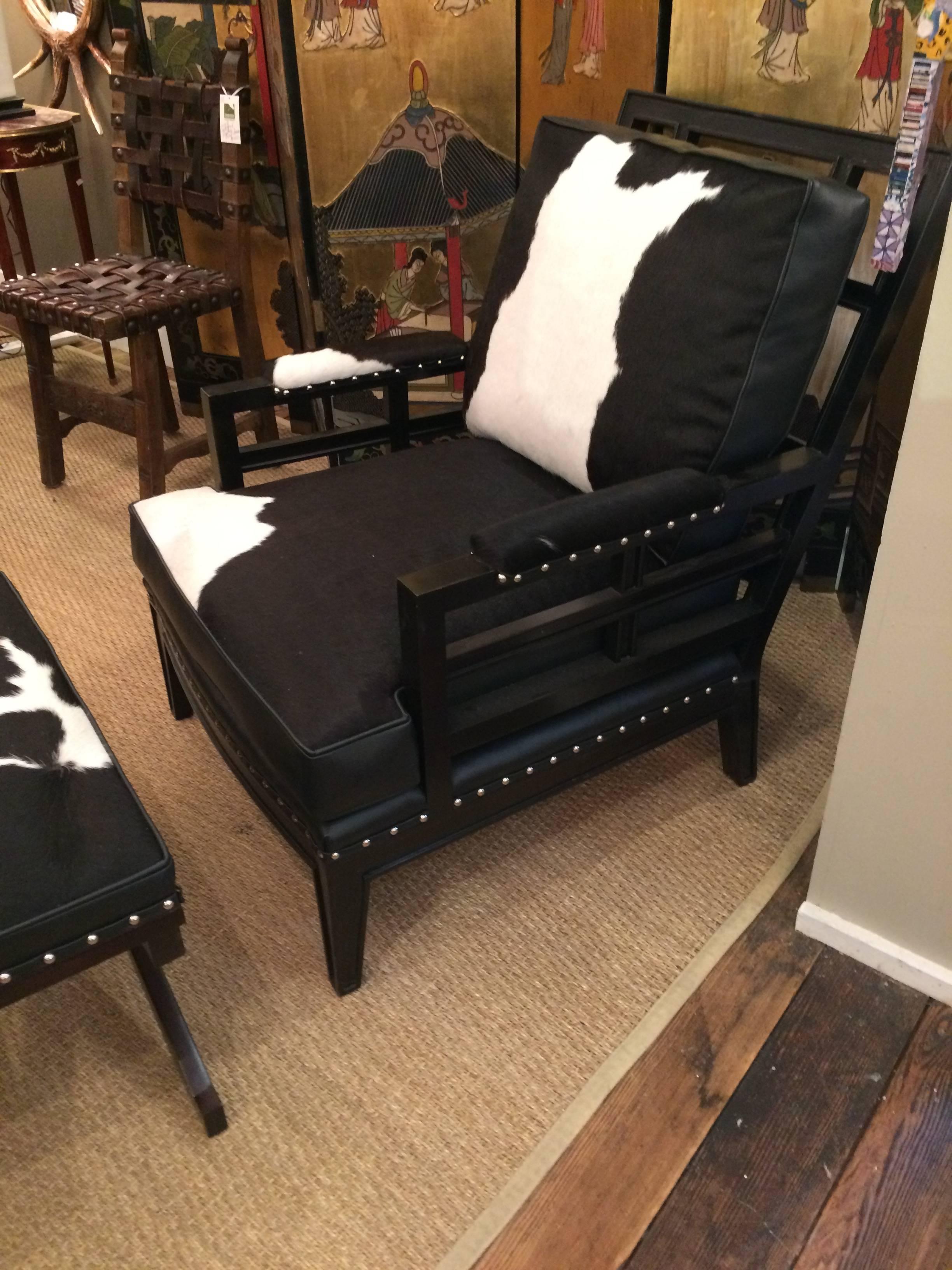 Fabulously chic custom club chair having ebonized wood and a mix of black leather and black and white cowhide upholstery, finished with nailheads.