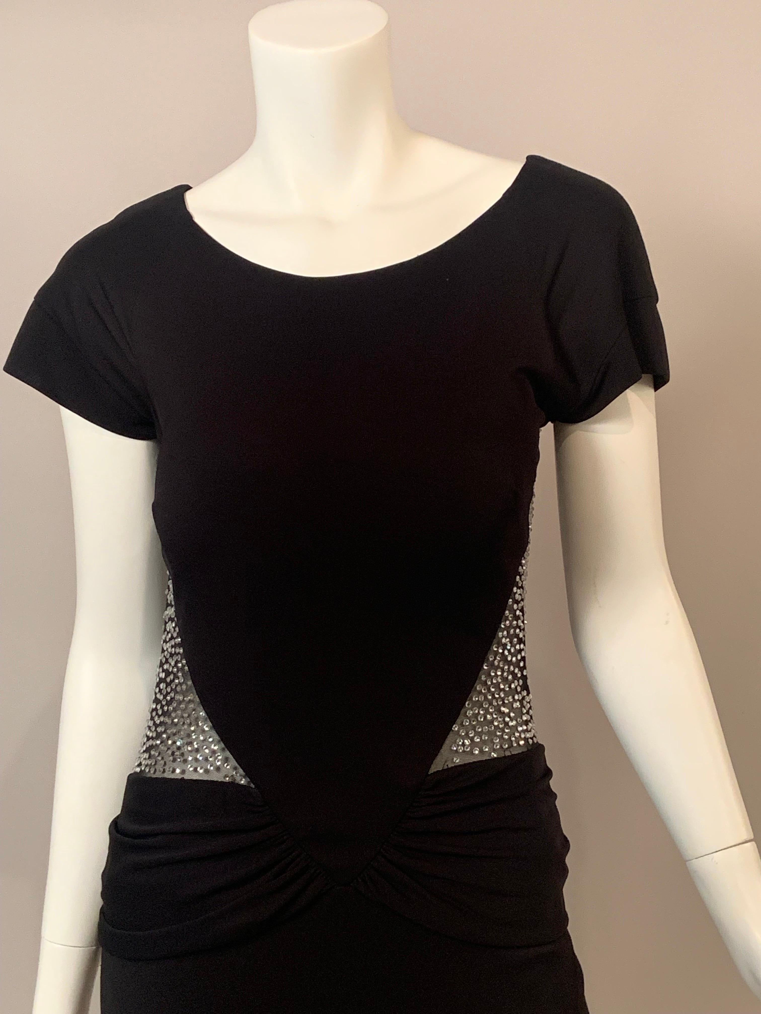 Dieses elegante, sexy schwarze Abendkleid hat  durchsichtiges schwarzes Netz an den Seiten und am Rücken. Es ist mit funkelnden Strasssteinen besetzt, die sich über einem breiten Strassband an der Taille befinden.  Darunter befindet sich ein
