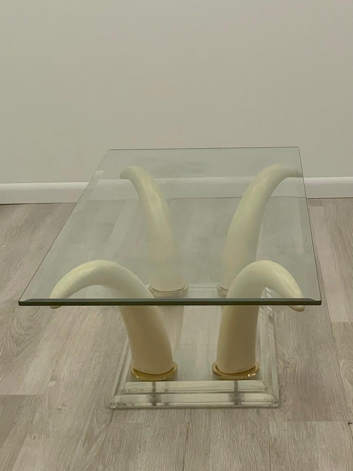 Super glamorous Mid-Century Modern rectangular glass coffee table having a sizzling hot faux Horn and lucite base with brass trim.

Meausres: 1/2