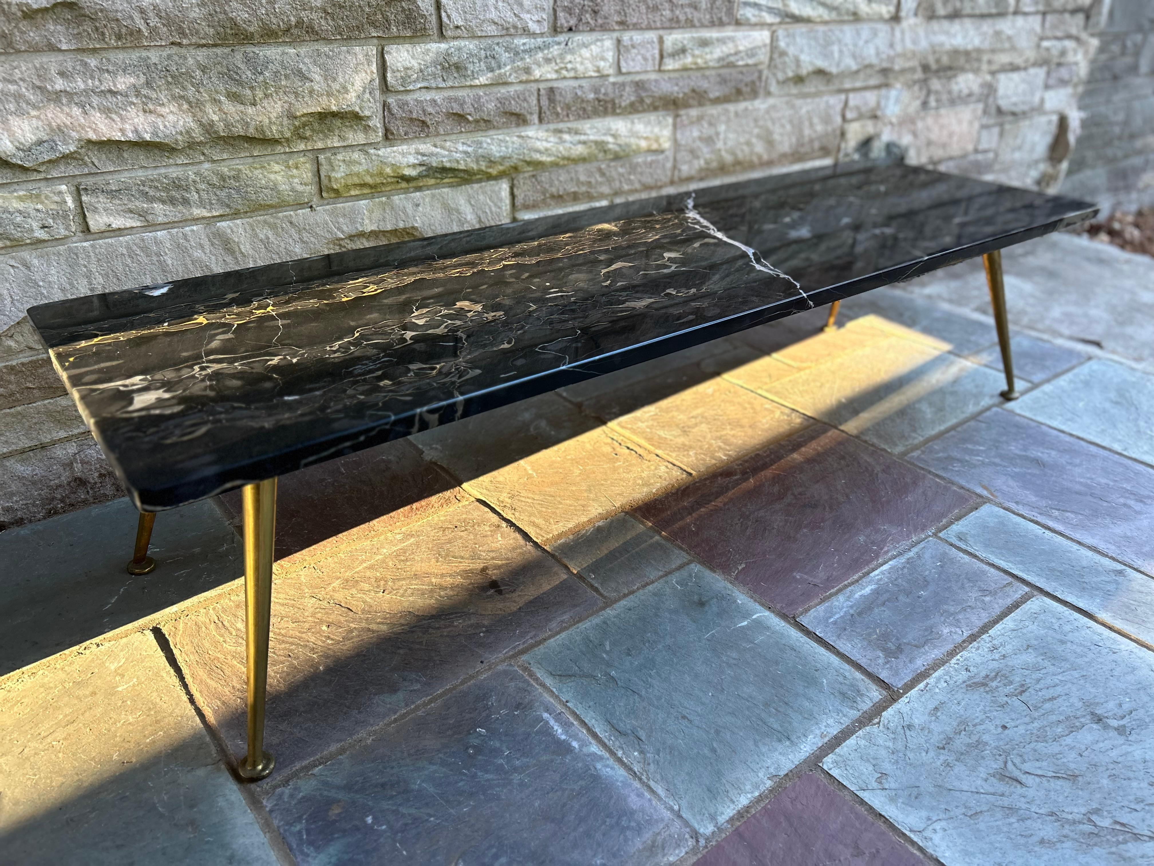 Sexy Gio Ponti style Italian black marble rectangular coffee table with interesting solid brass splayed legs.  It measure 13.75