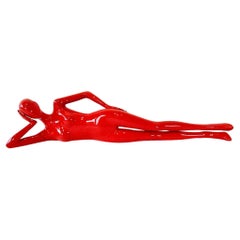 Mujer sexy en escultura maniquí roja en reposo de cabeza sobre mano