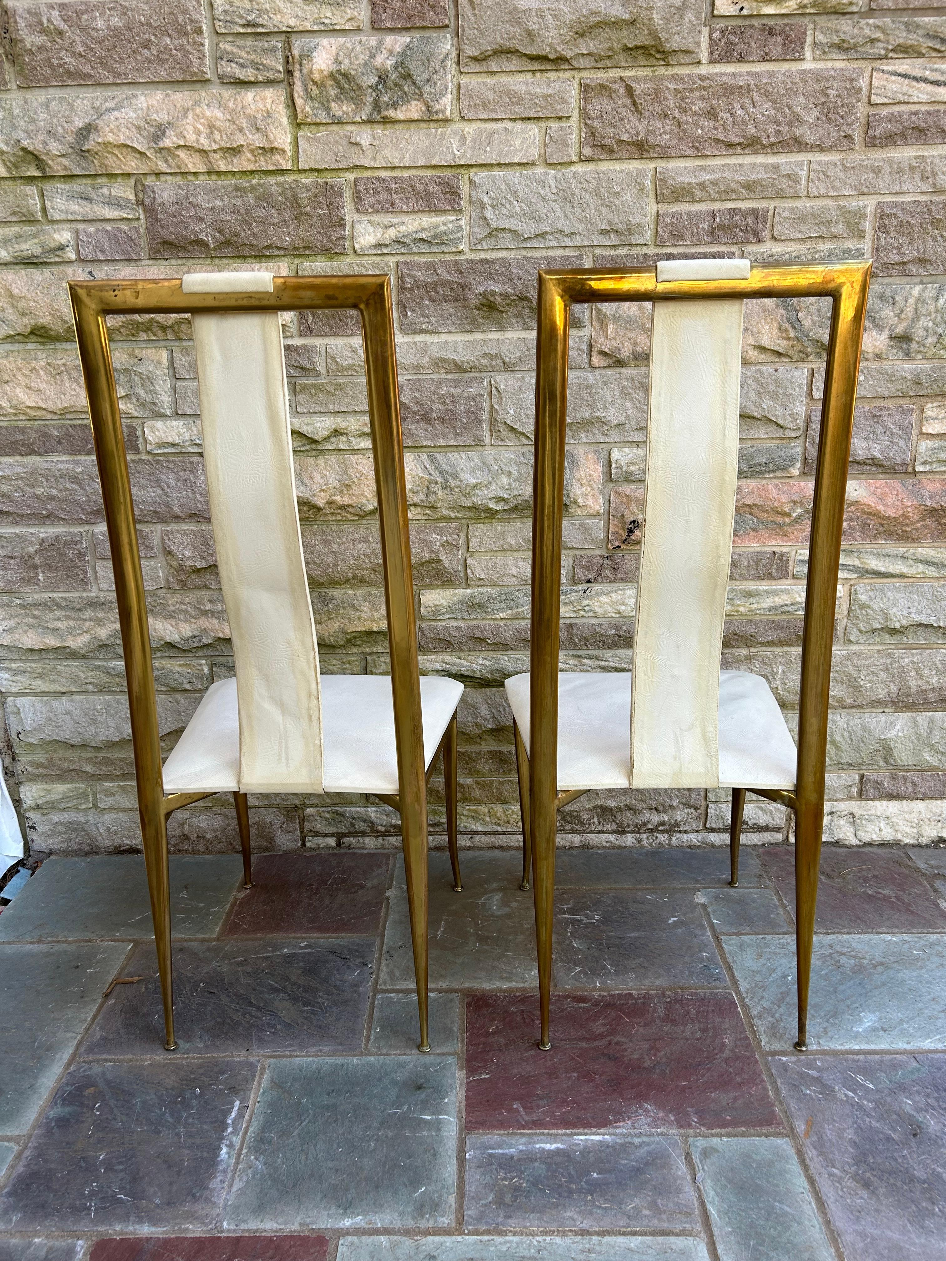Sexy pair Italian Gio Ponti style brass dining chairs with open back and tapered legs.  They measure 44.5