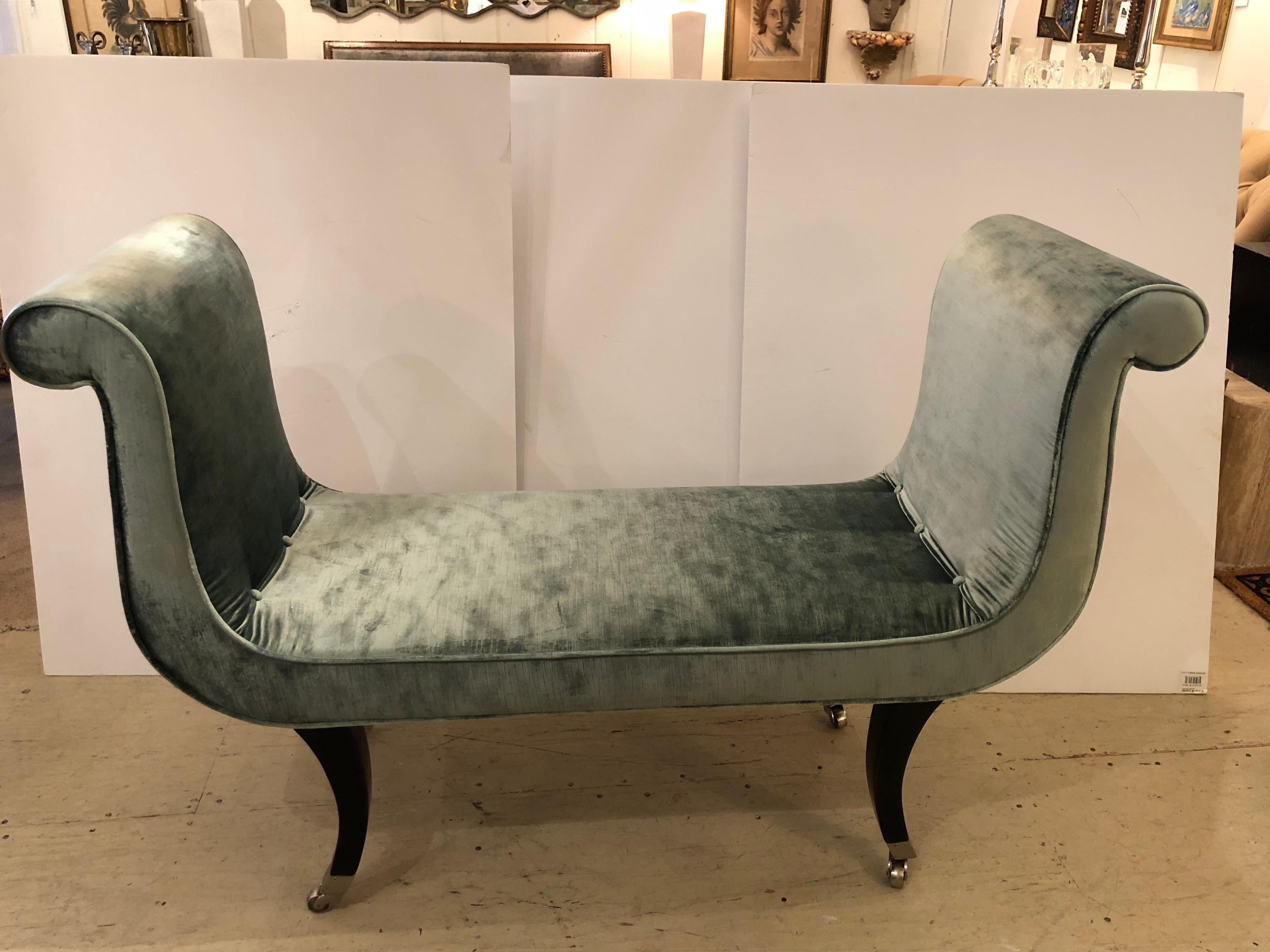 Super elegant U-form bench newly upholstered in ice blue silk velvet. The bench has scrolling arms and ebonized curved legs that terminate in nickel plated feet with casters.