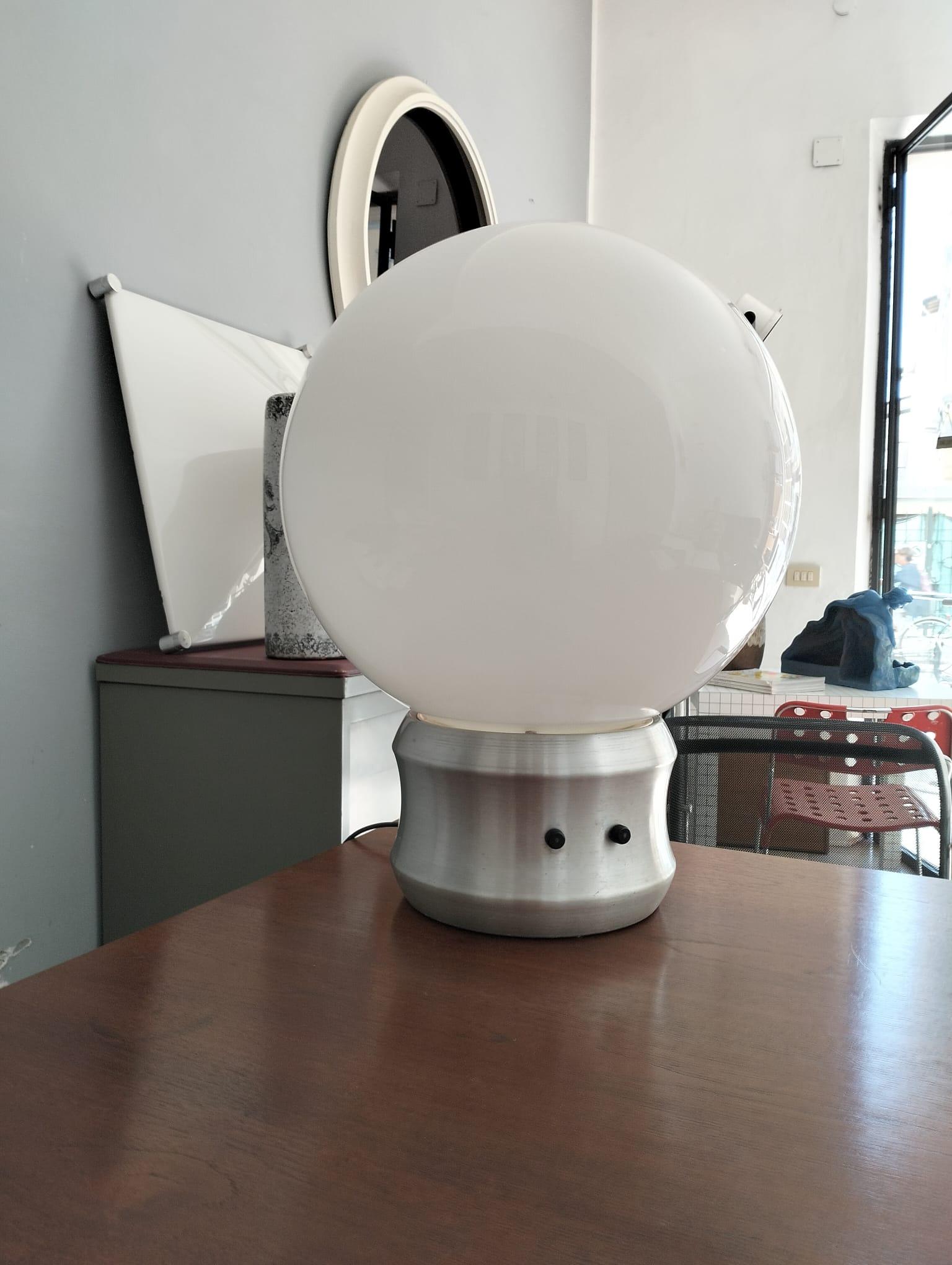 Sphère géante  grande lampe de table dessinée par Elio Martinelli en 1960 et produite par Martinelli Luce. Le globe est en verre opalescent monté sur une base en métal chromé. A l'intérieur, il y a une grande lampe et trois petites. 