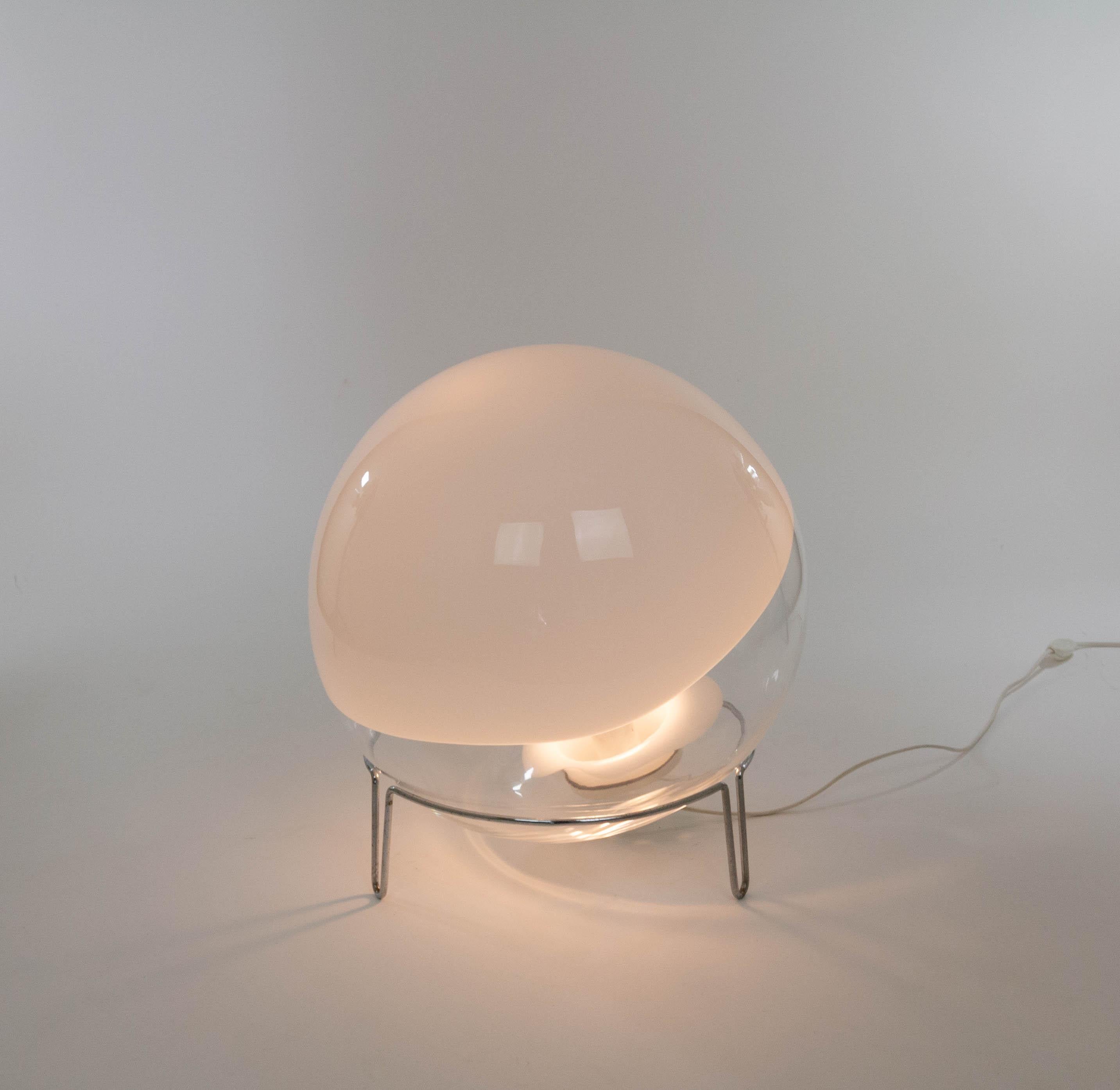 A Sfera table or floor lamp designed by Angelo Mangiarotti for Skipper Pollux, 1980s.

The lamp consists of white and transparent Murano glass and a chromed metal frame. The glass sphere can be positioned in all directions in the metal frame. The